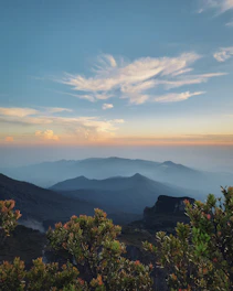 A scenic view of a mountain range at sunset