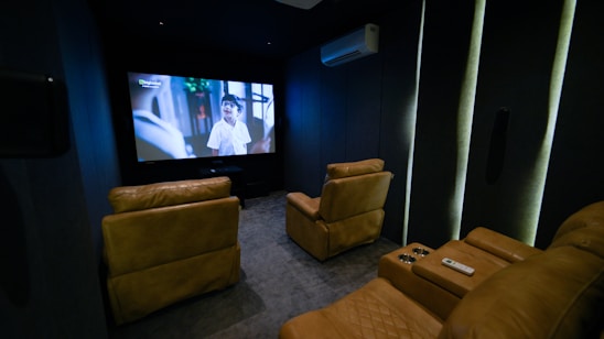 A home theater with two recliners and a flat screen TV