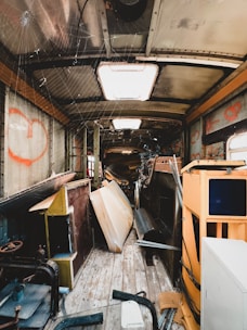 The inside of a bus with lots of junk on the floor