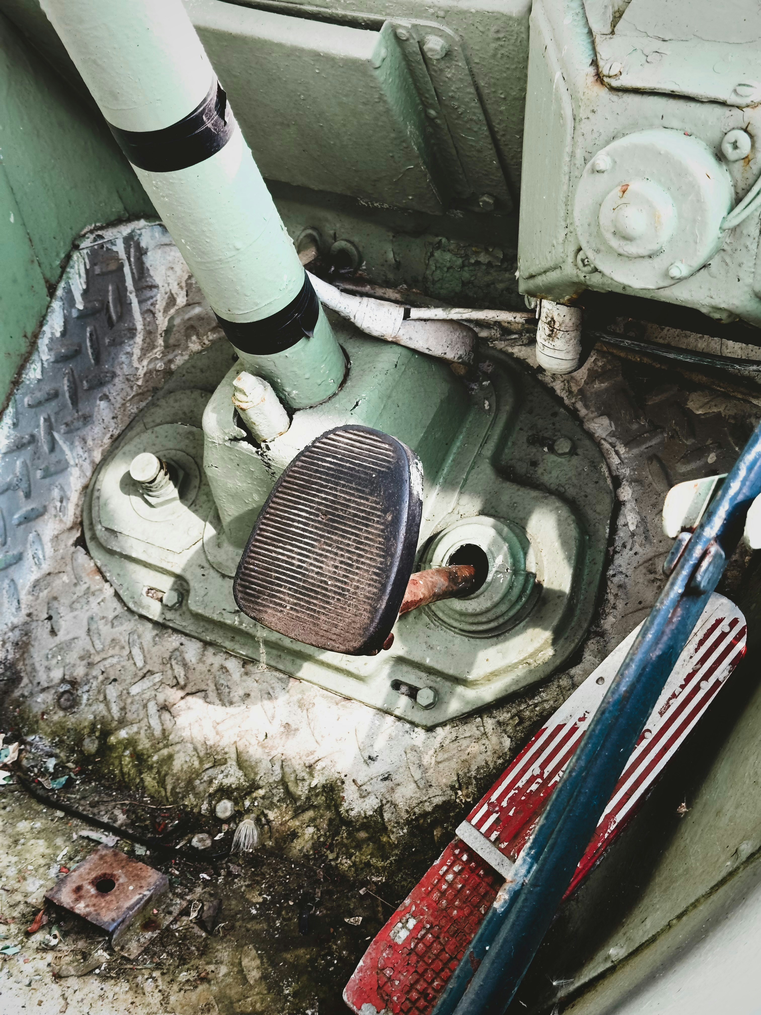 A dirty toilet with a pipe in the middle of it
