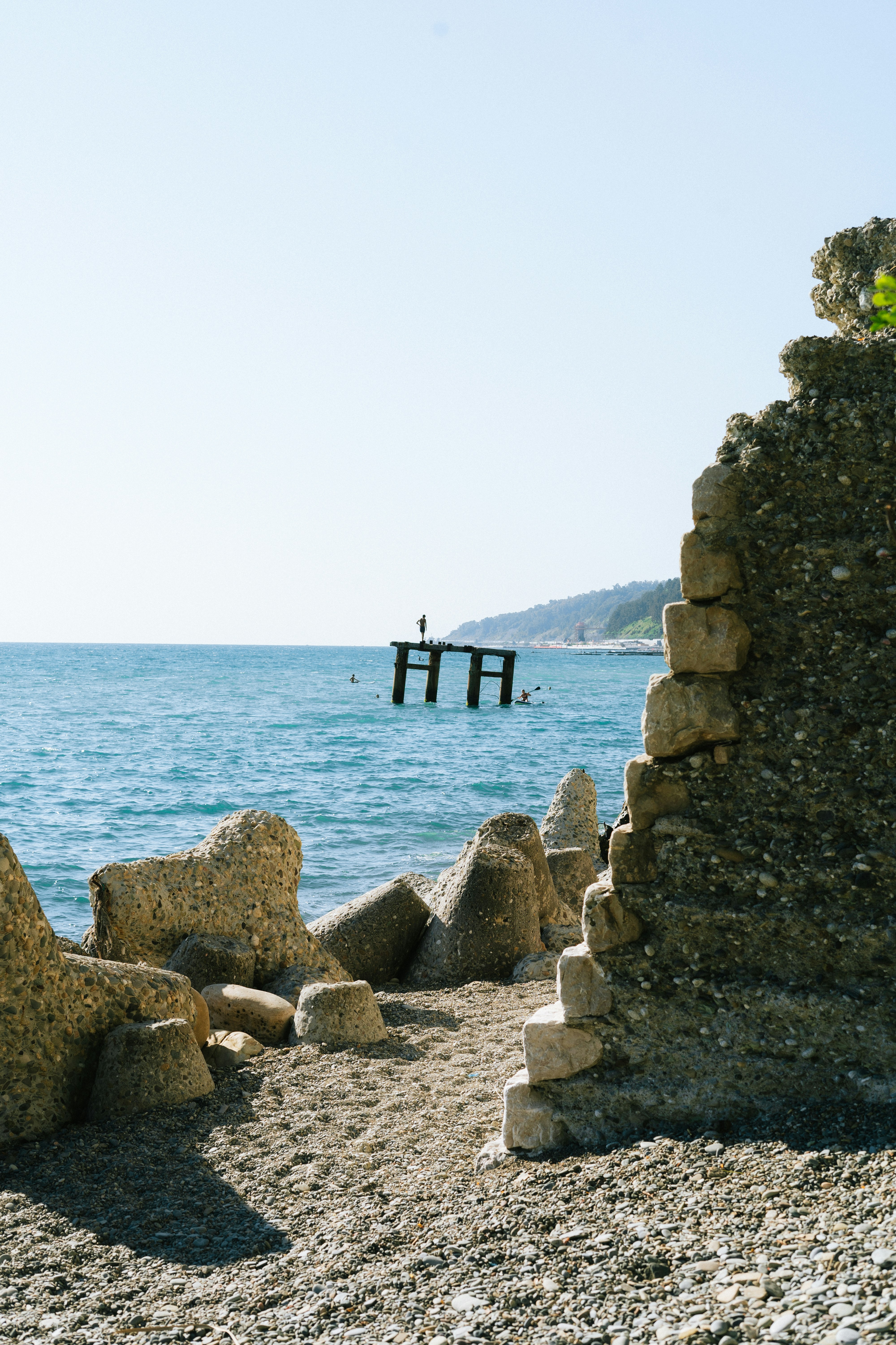 A stone structure sitting on top of a beach next to the ocean