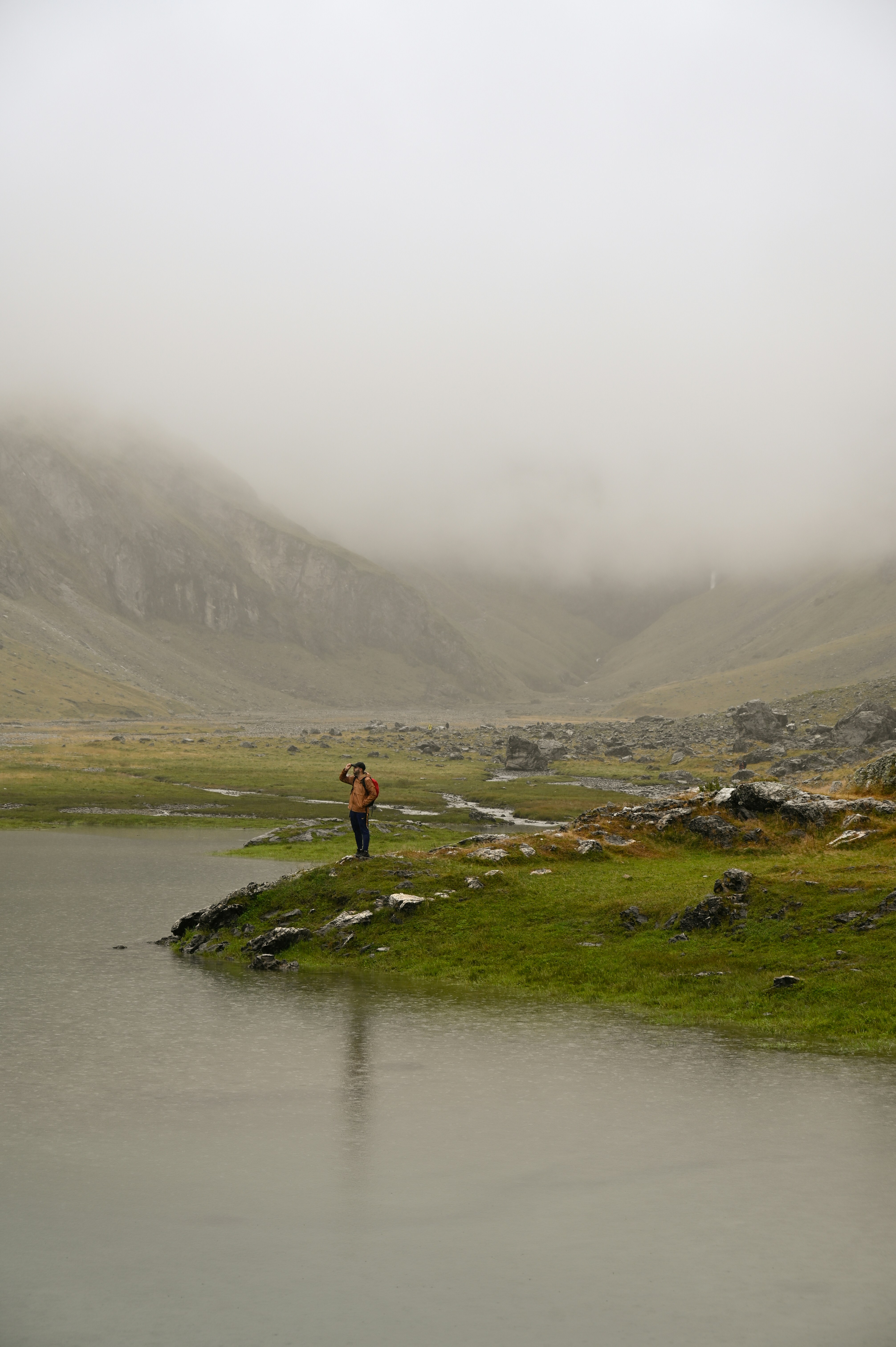 A person standing on a small island in the middle of a lake