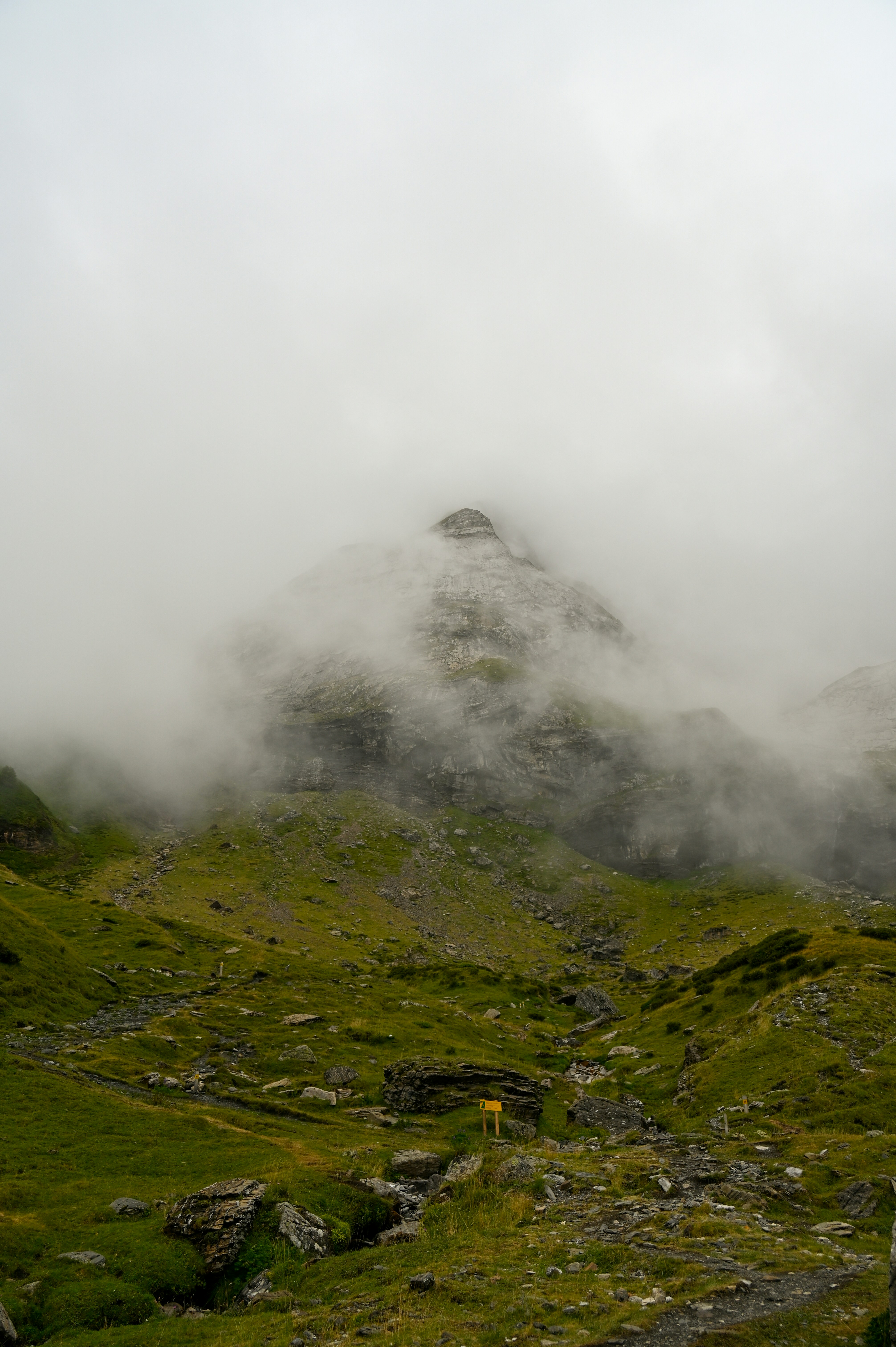 A mountain covered in fog and clouds on a cloudy day