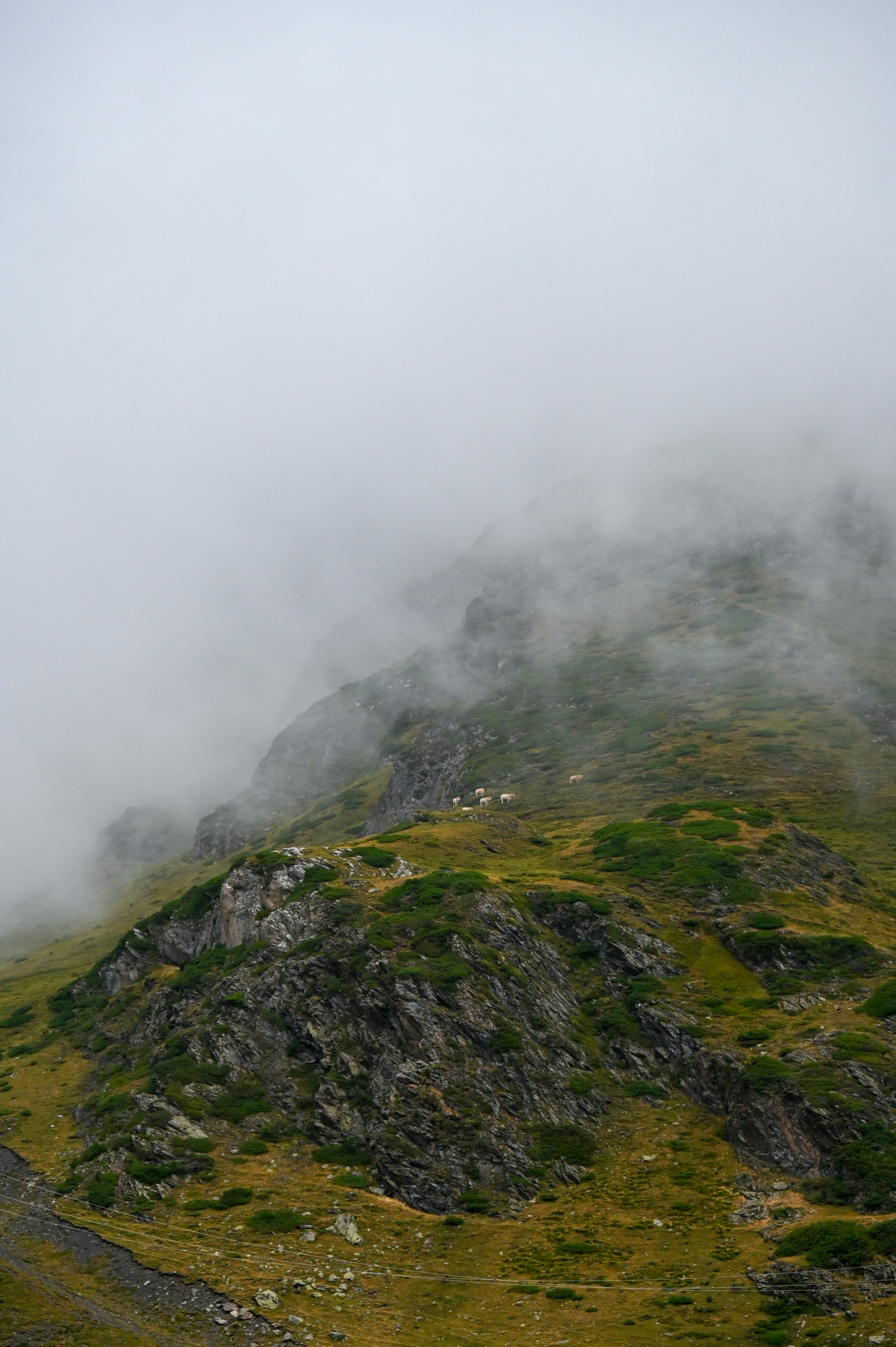 A mountain covered in fog and clouds on a cloudy day