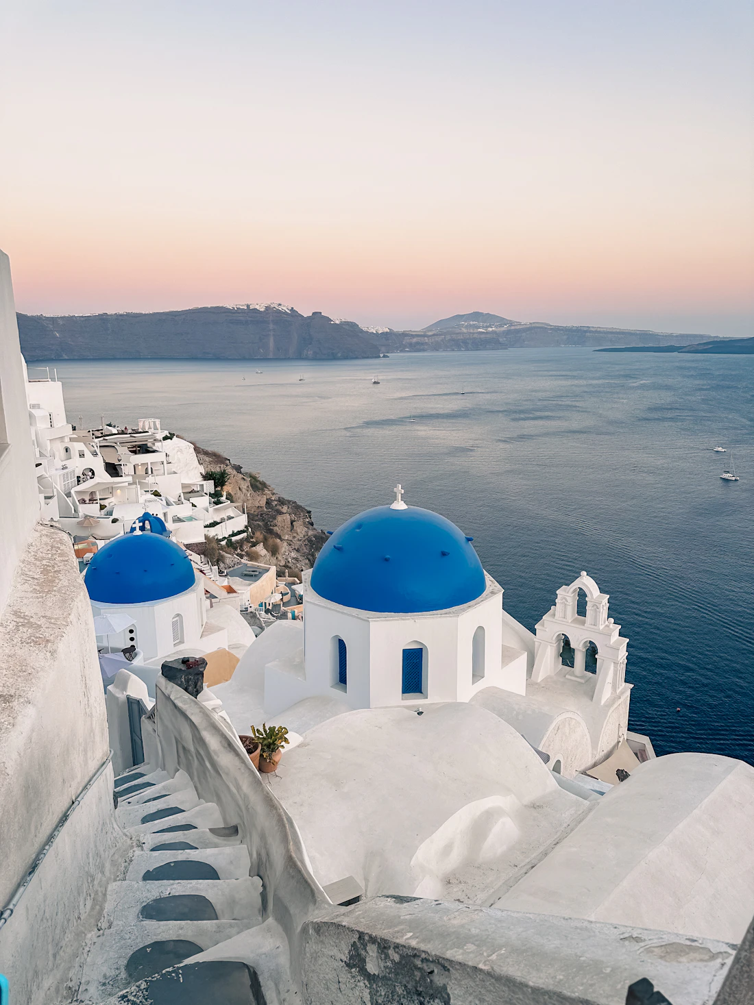 Whitewashed Cycladic village perched on a caldera cliff above the deep blue Aegean Sea