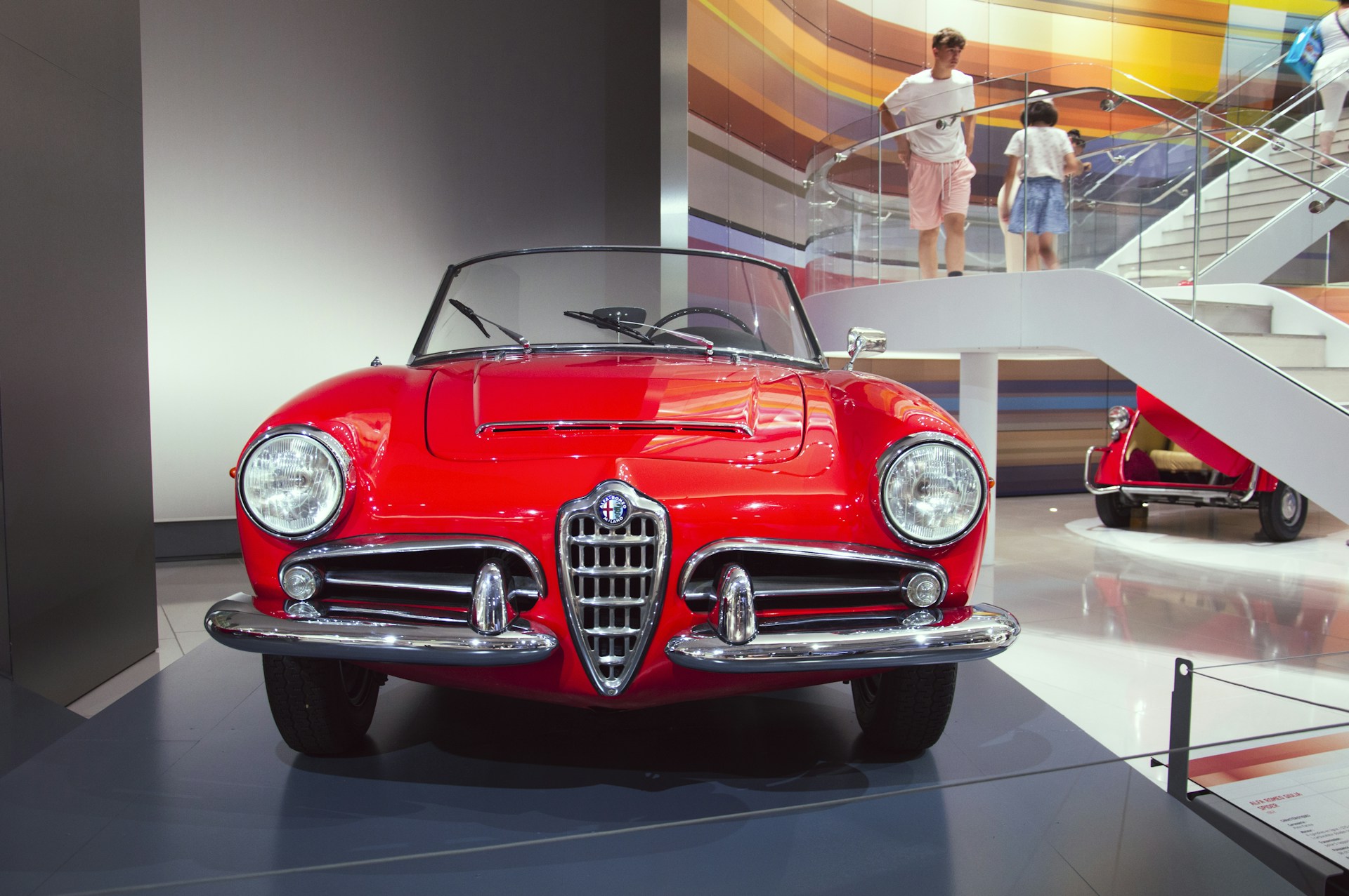 A red car is on display in a museum