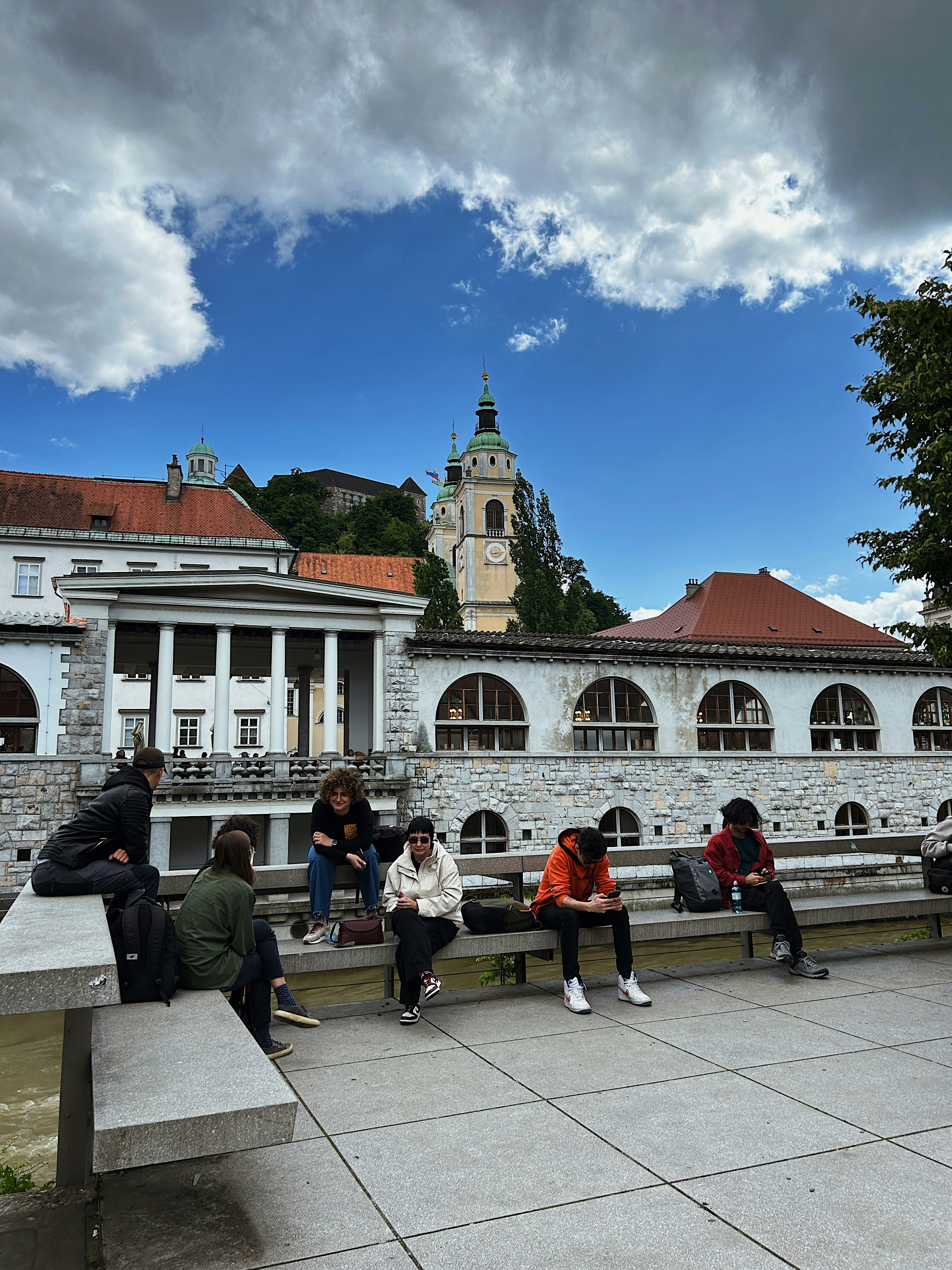 A group of people sitting on benches in front of a building