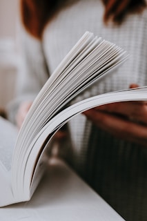 A woman reading a book on a table