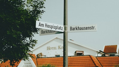 A street sign on a pole in front of a building