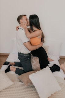 A man and woman kissing on a bed