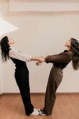 A couple of women standing on top of a hard wood floor