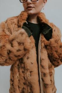 A woman wearing glasses and a fur coat