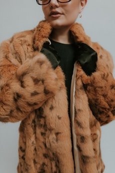 A woman wearing glasses and a fur coat