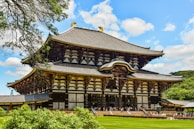 A large wooden building sitting on top of a lush green field