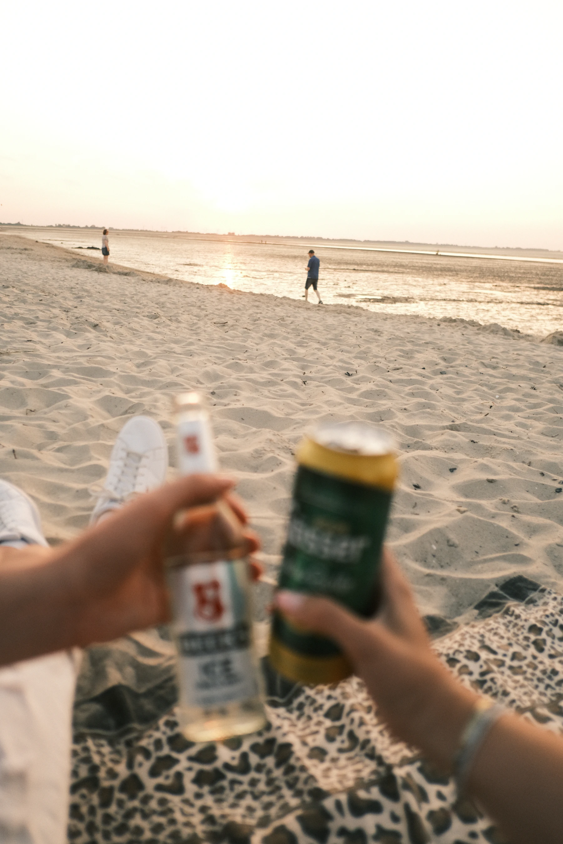 cta-lifestyle — person holding a sparkling can on the beach at golden hour