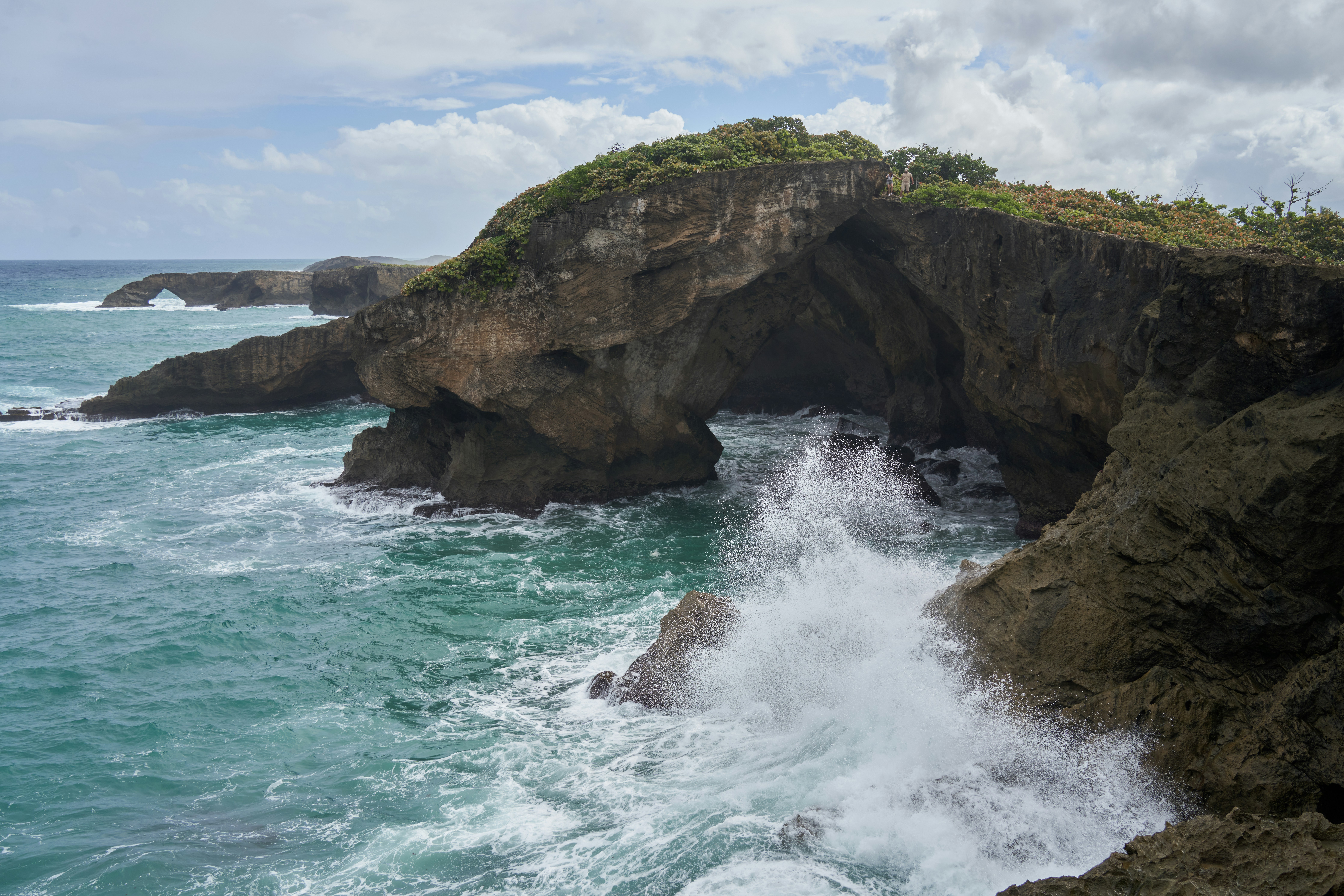 A large body of water next to a rocky cliff, 