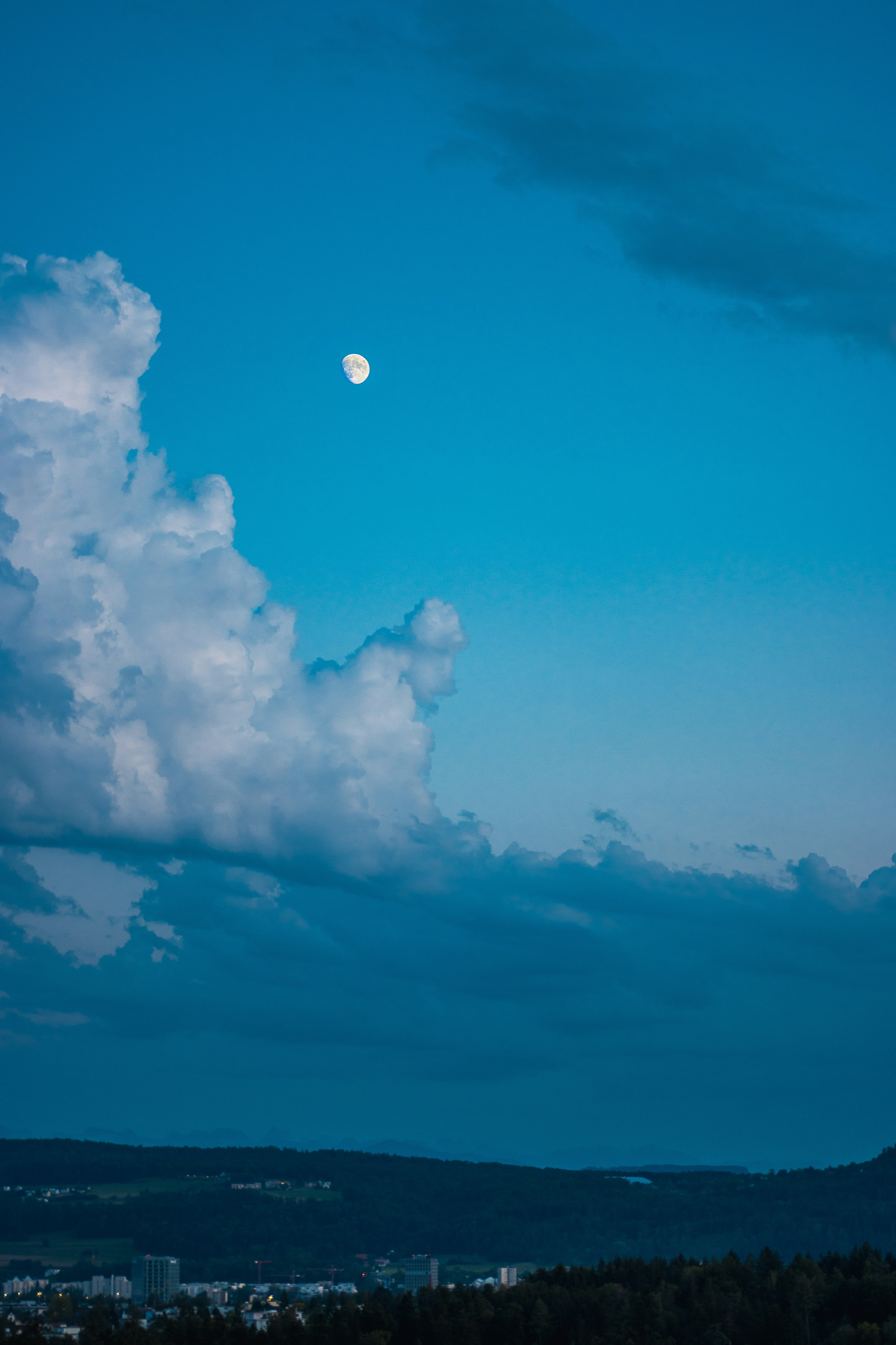 A full moon is seen in the sky above a city