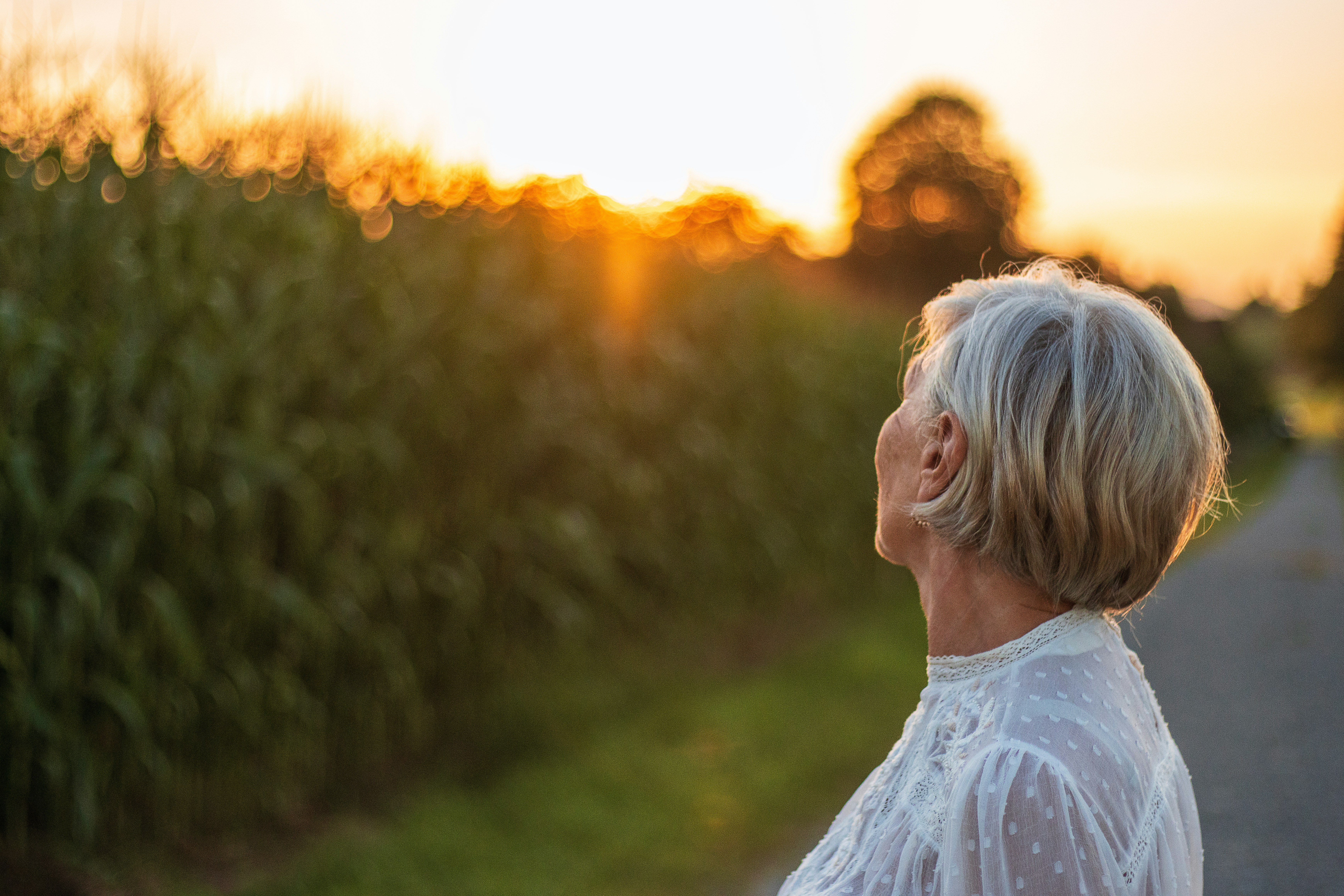 A woman walking down a road at sunset