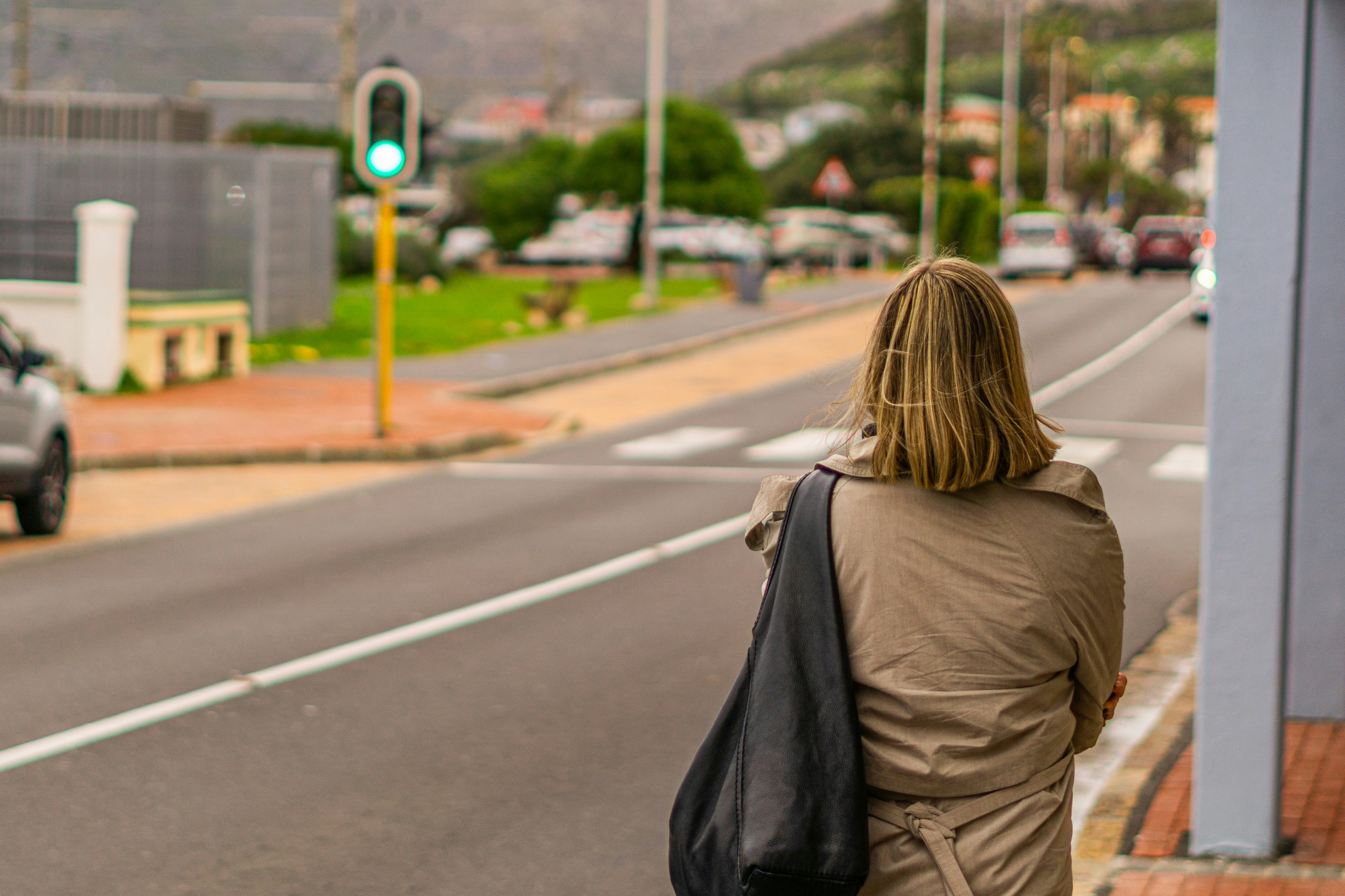 A woman is walking down the street with a bag
