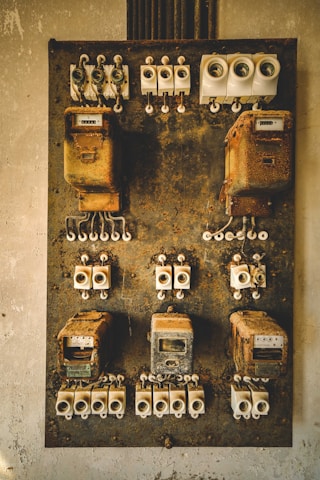 A bunch of old electrical equipment hanging on a wall