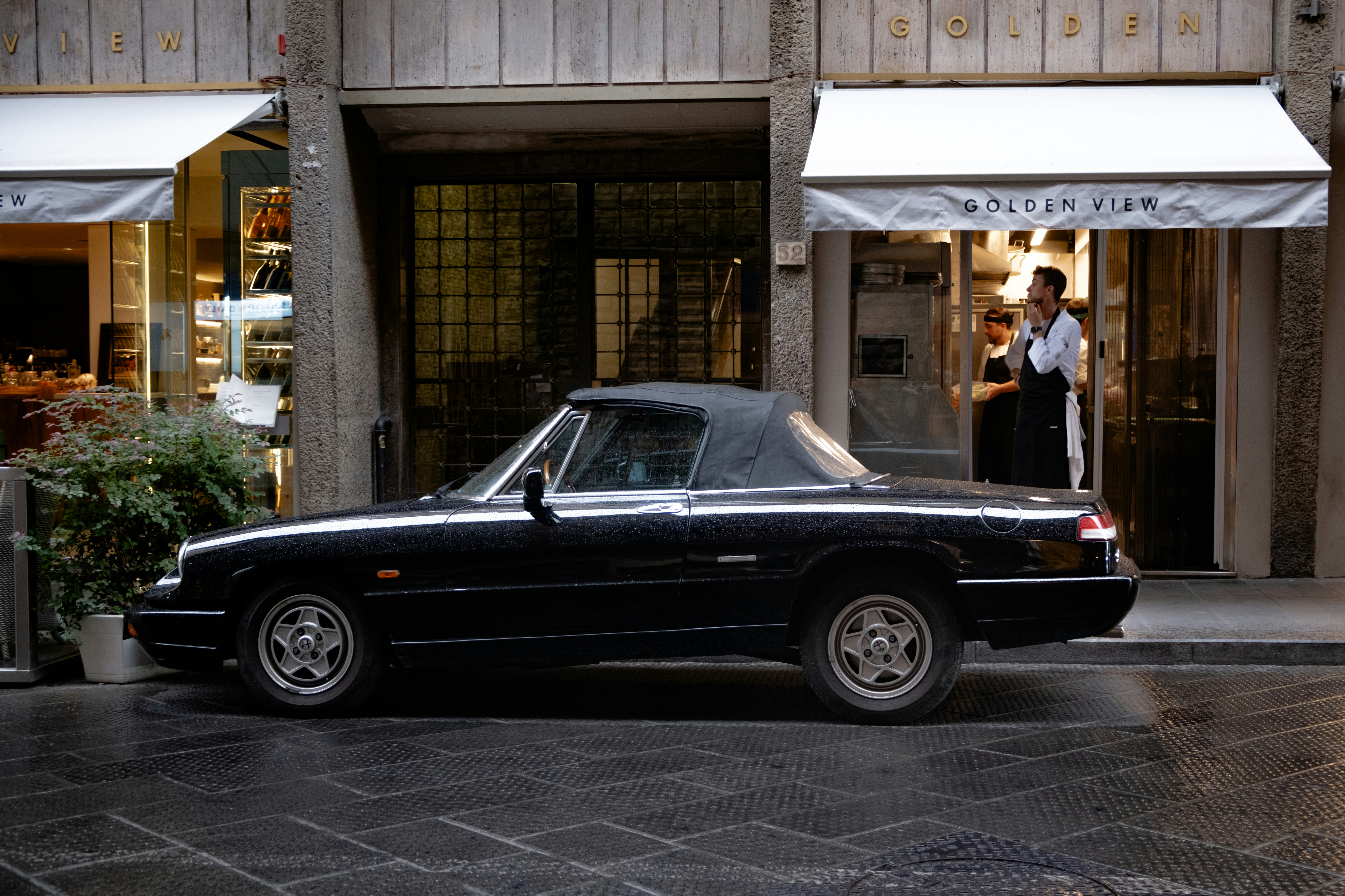 A black car parked in front of a building