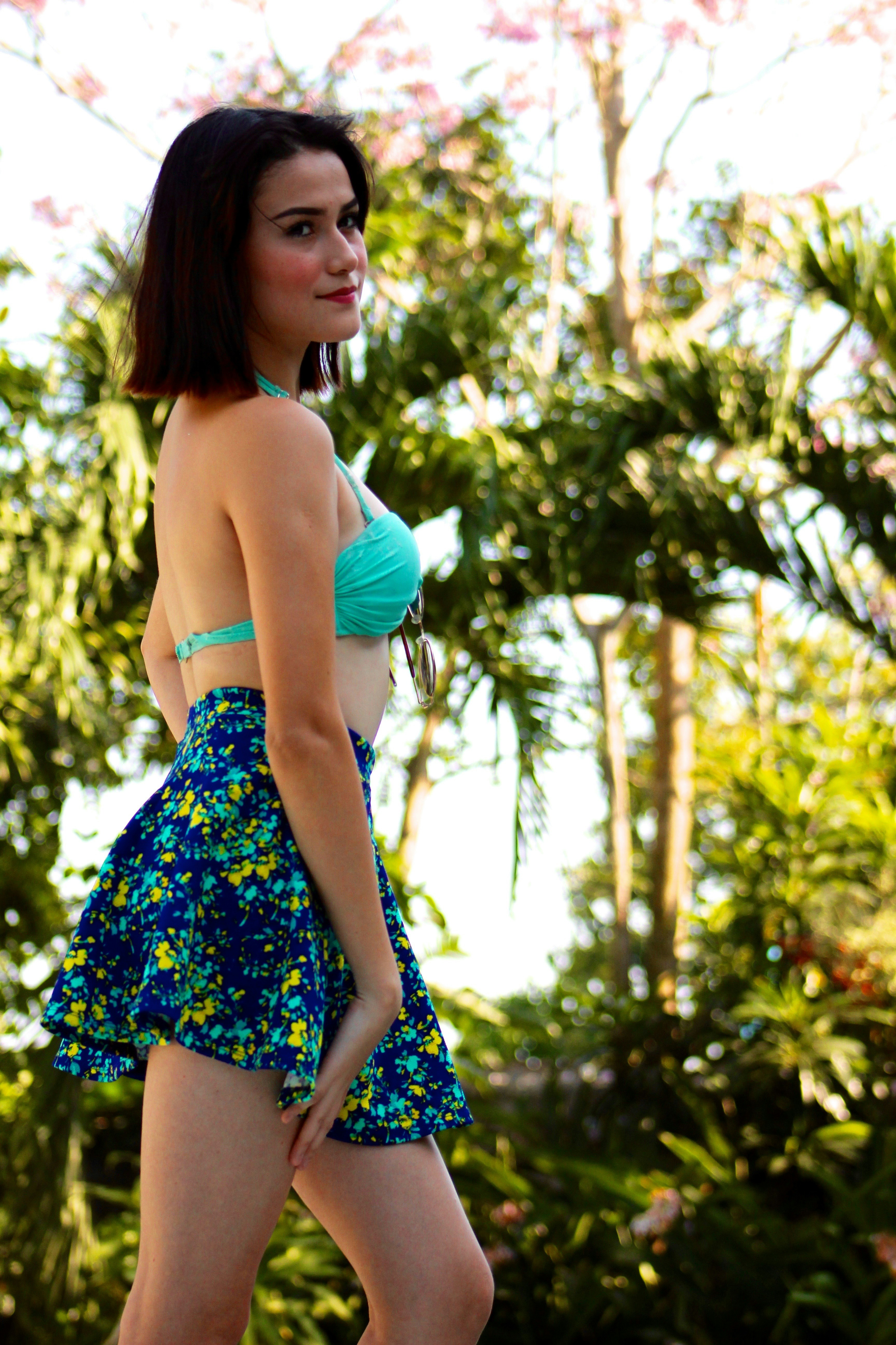 파란색 비키니 상의와 파란색과 녹색 치마를 입은 여성