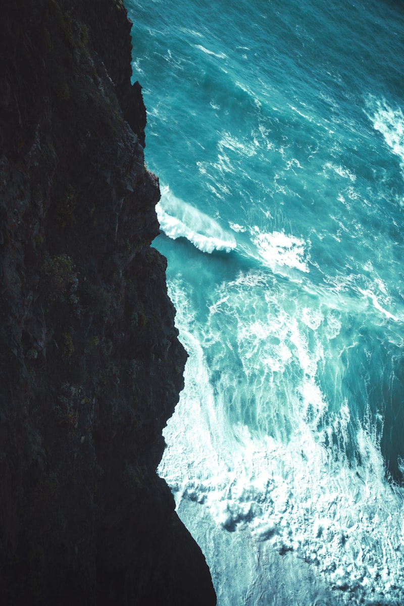 Un uomo in piedi sulla cima di una scogliera affacciata sull'oceano