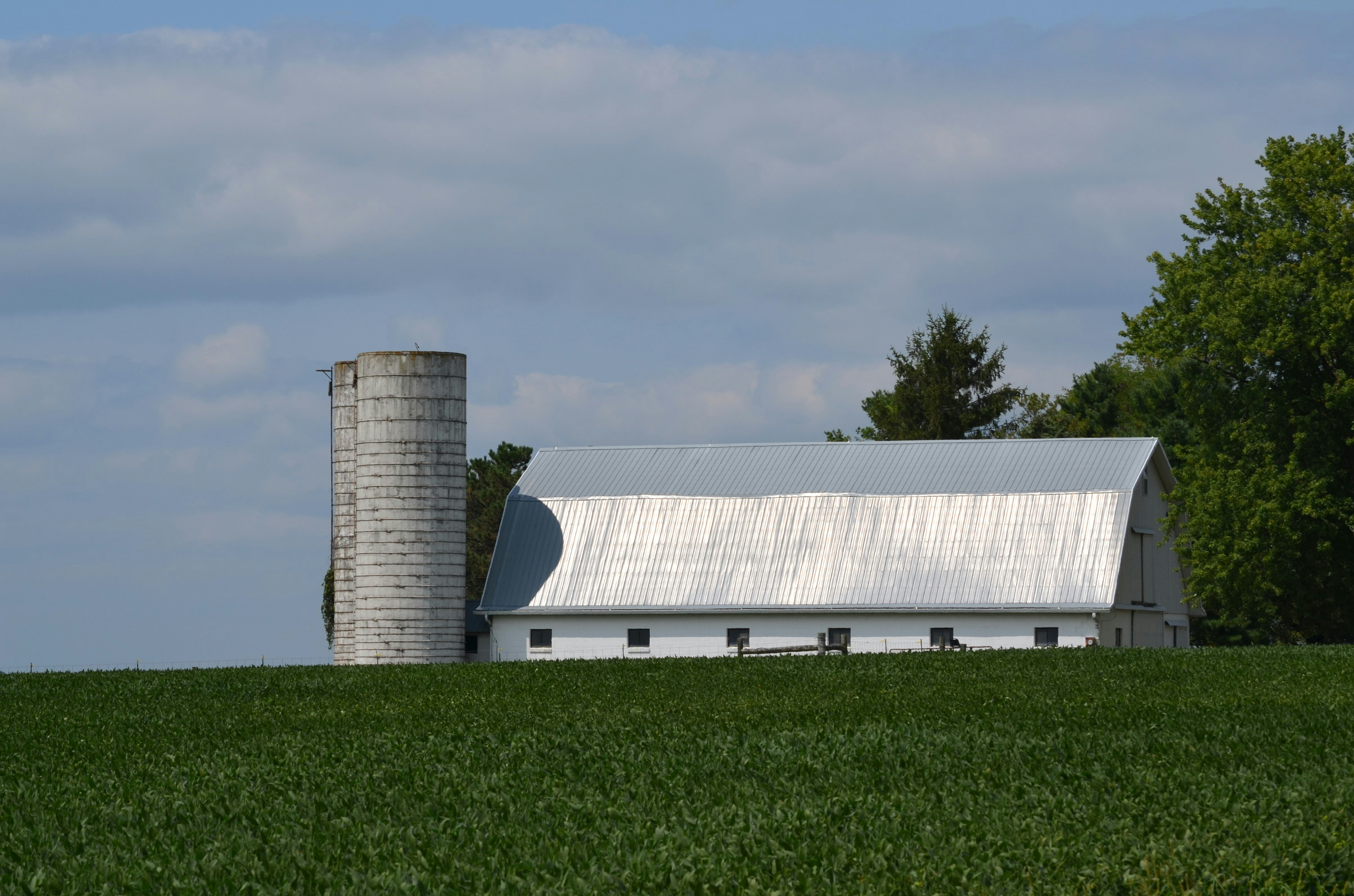 Una granja con un granero y un silo al fondo foto – Imagen de Edificio  gratuita en Unsplash, image size:3000x1987