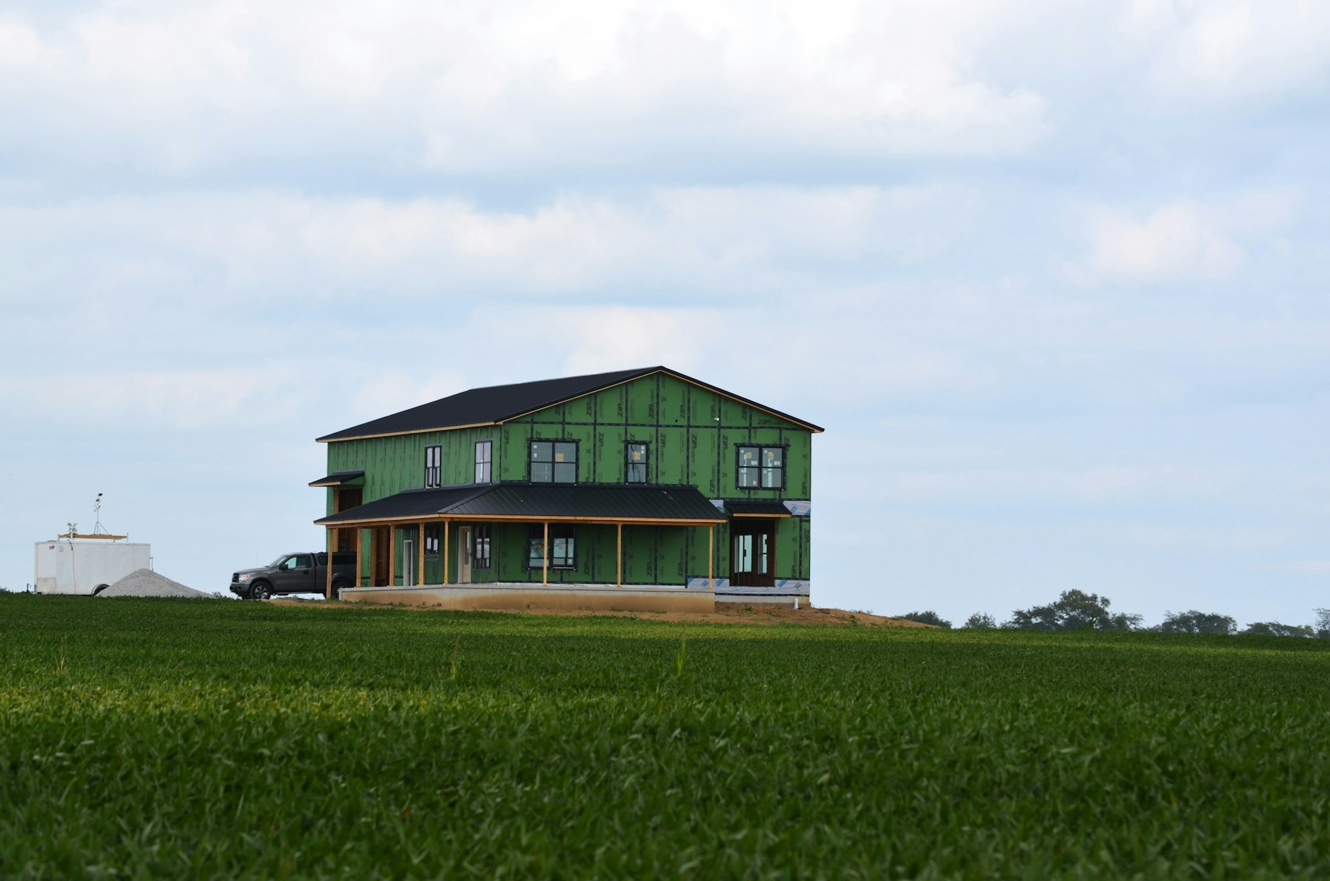 A green house in the middle of a green field