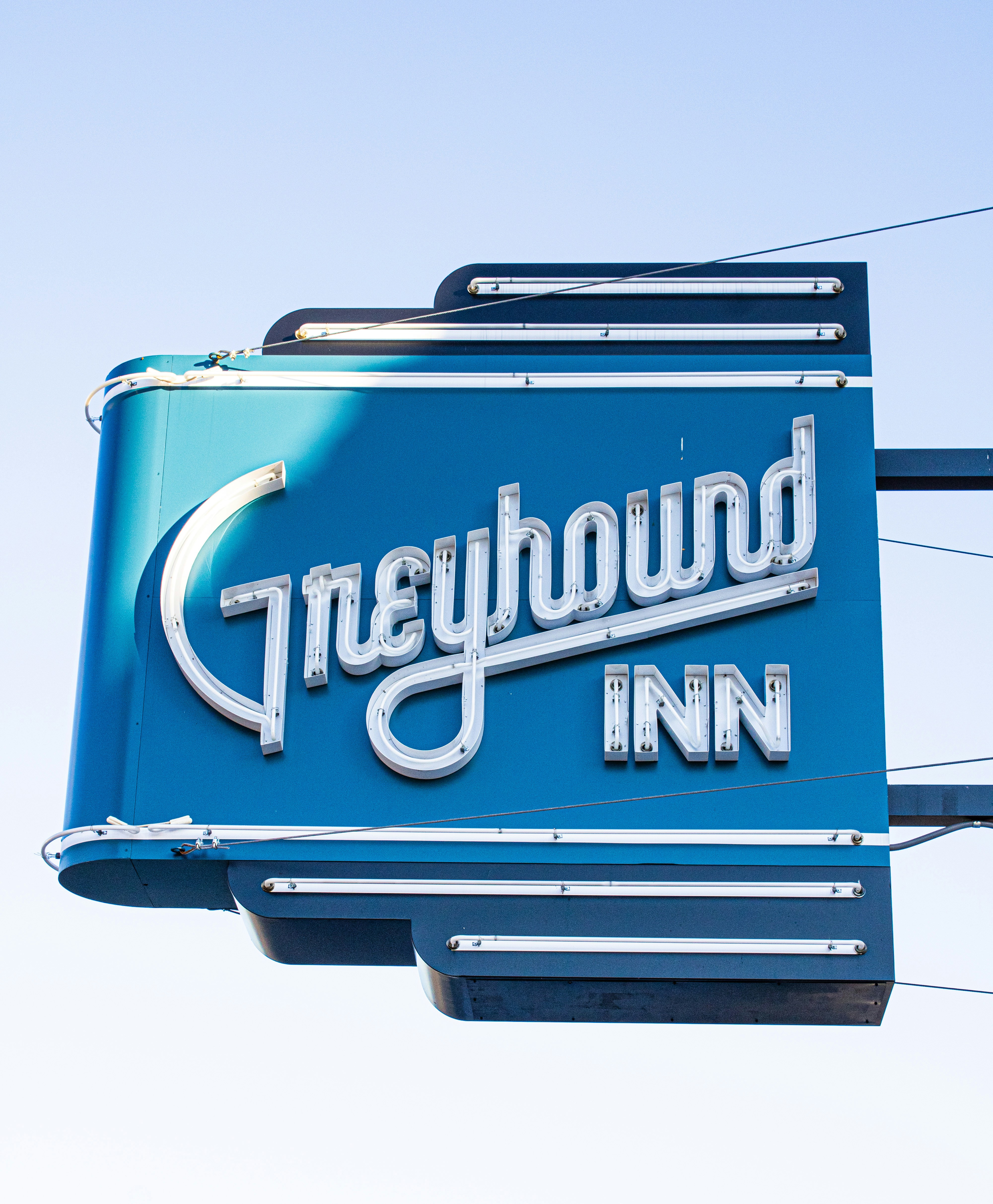 A blue sign hanging from the side of a building