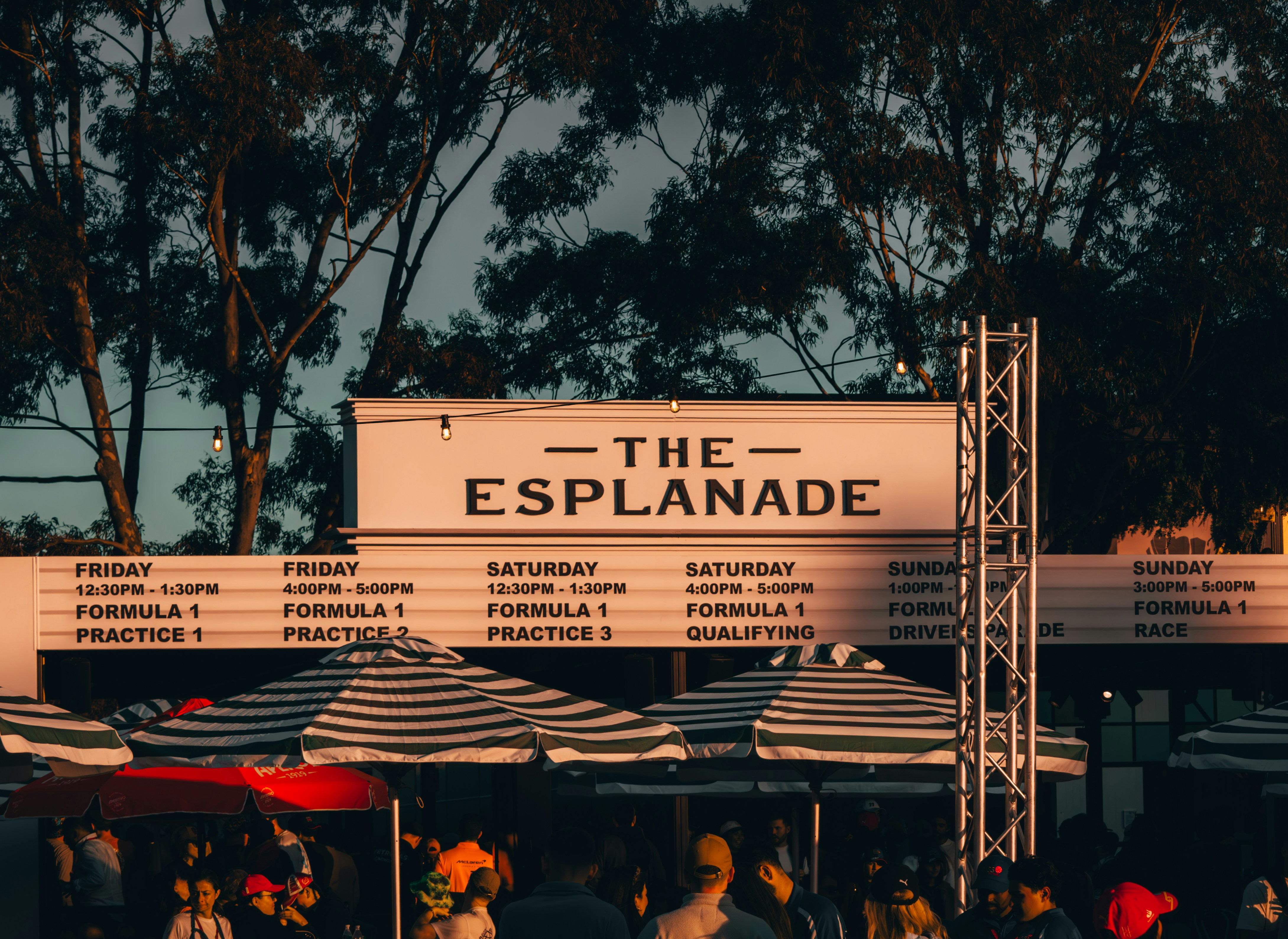 Un groupe de personnes debout sous des parapluies devant un bâtiment