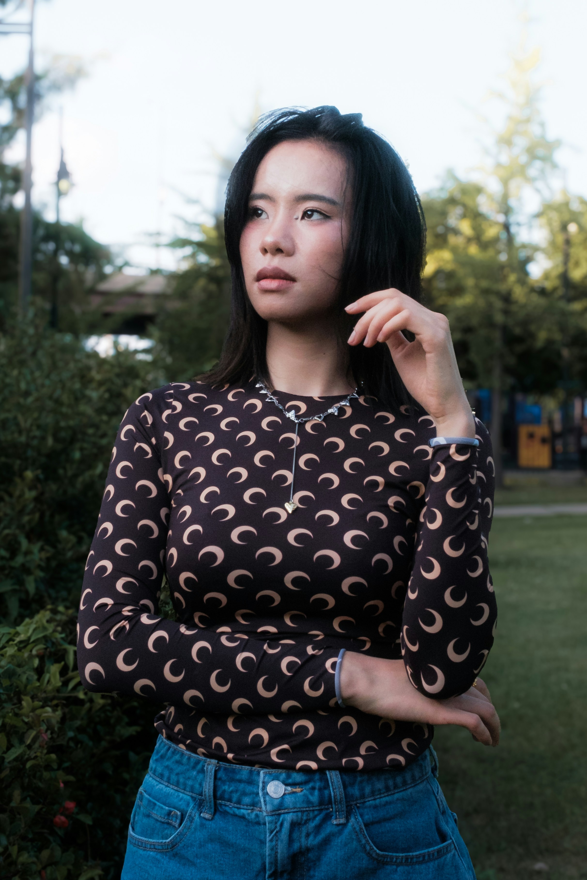 A woman standing in front of some bushes