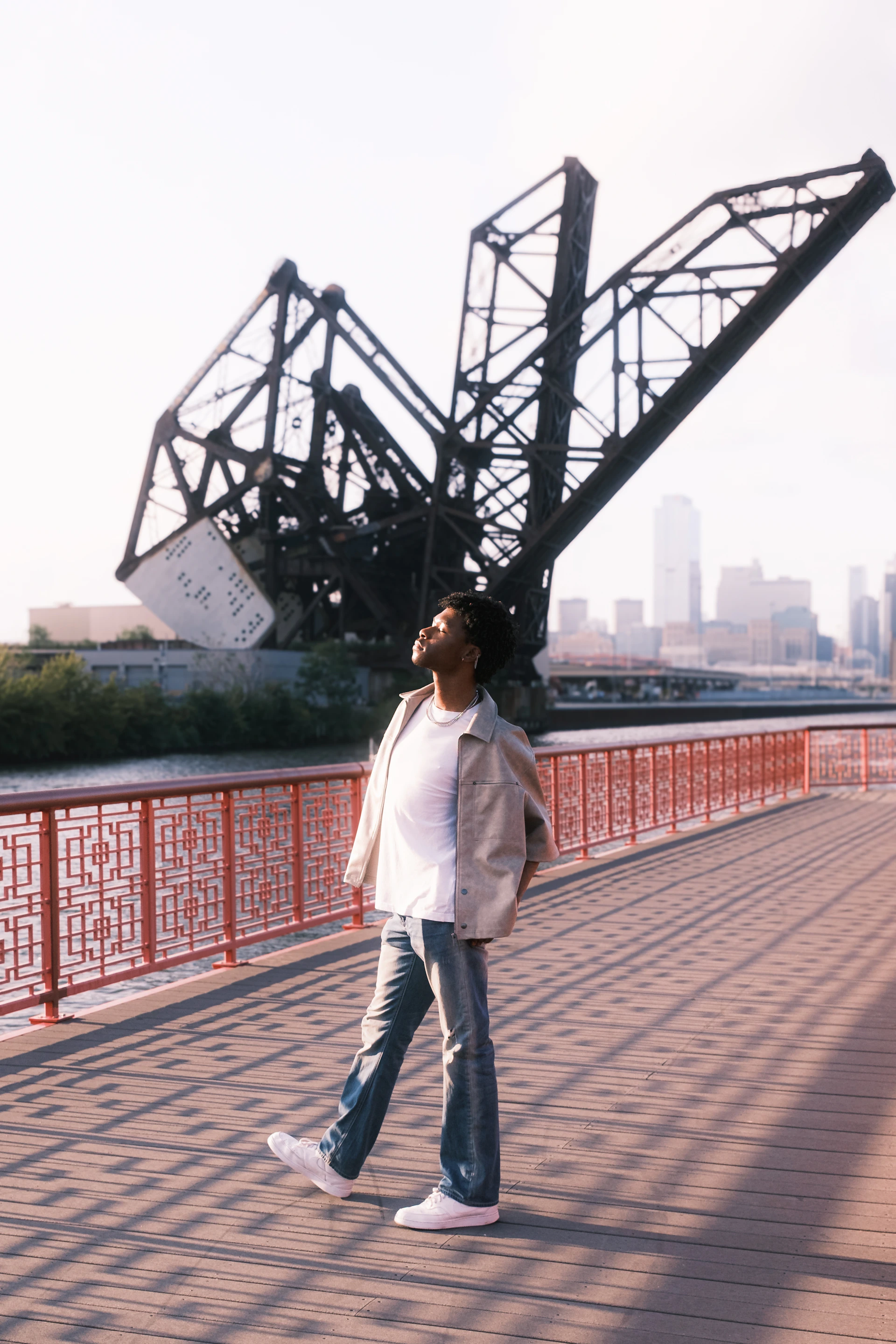 A man walking across a bridge over a river