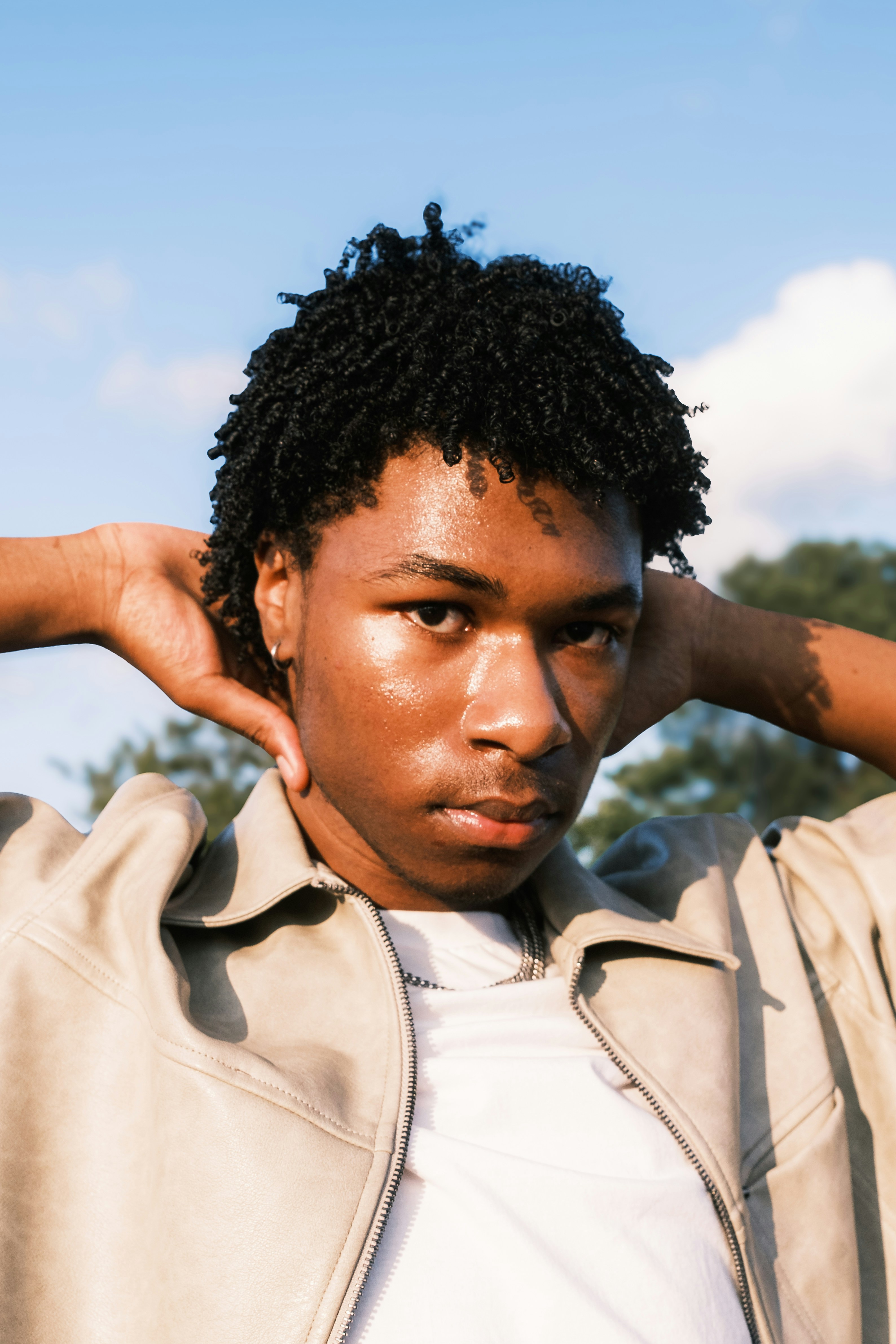 A man in a jacket is holding his hand on his head