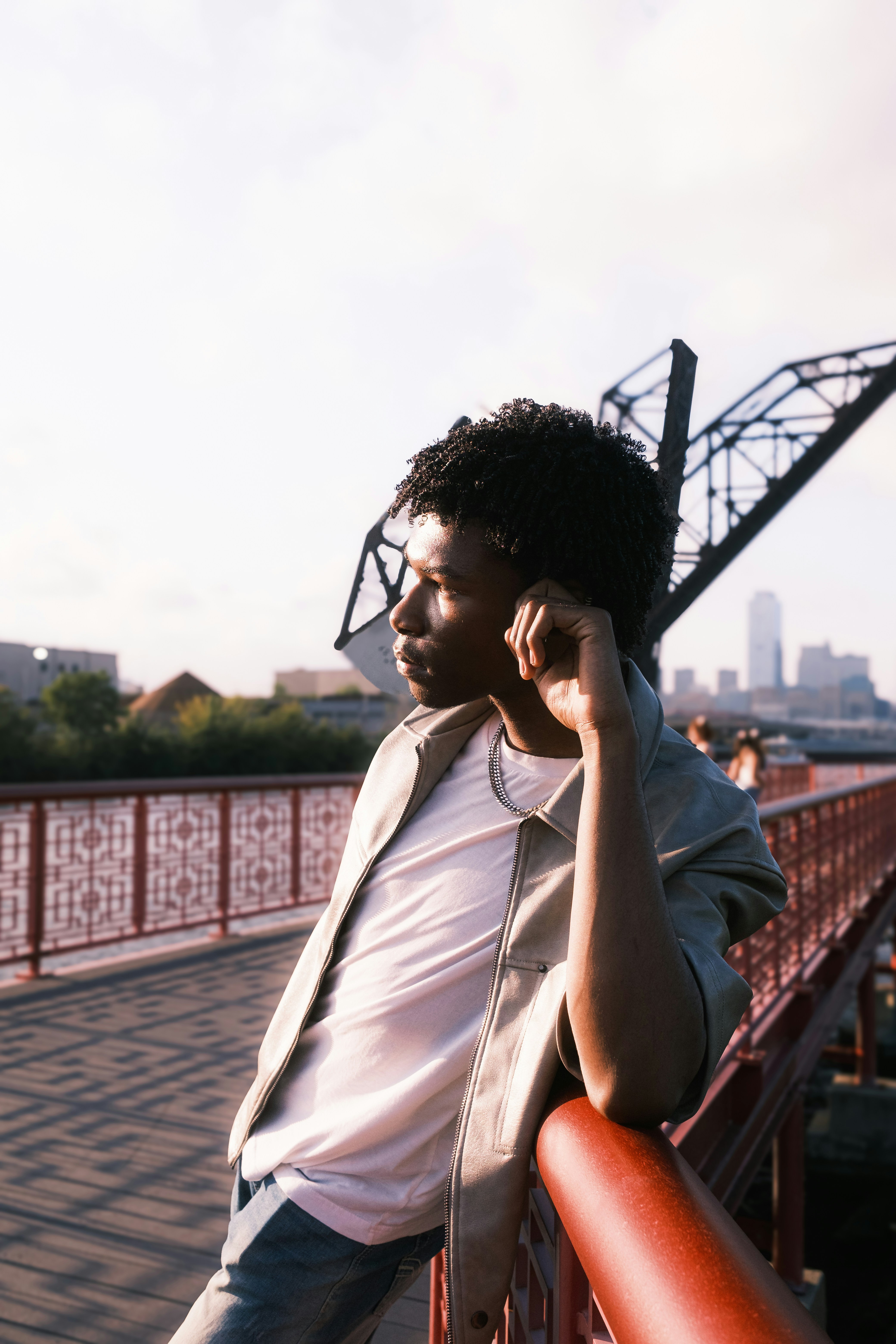 Um homem em pé em uma ponte falando em um telefone celular