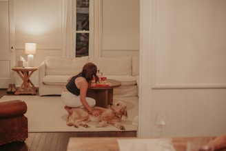 A woman sitting on the floor next to a dog