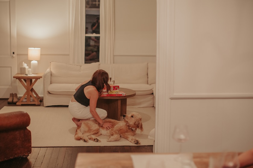 A woman sitting on the floor next to a dog