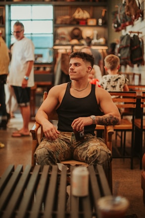 A man sitting in a chair in a room full of people