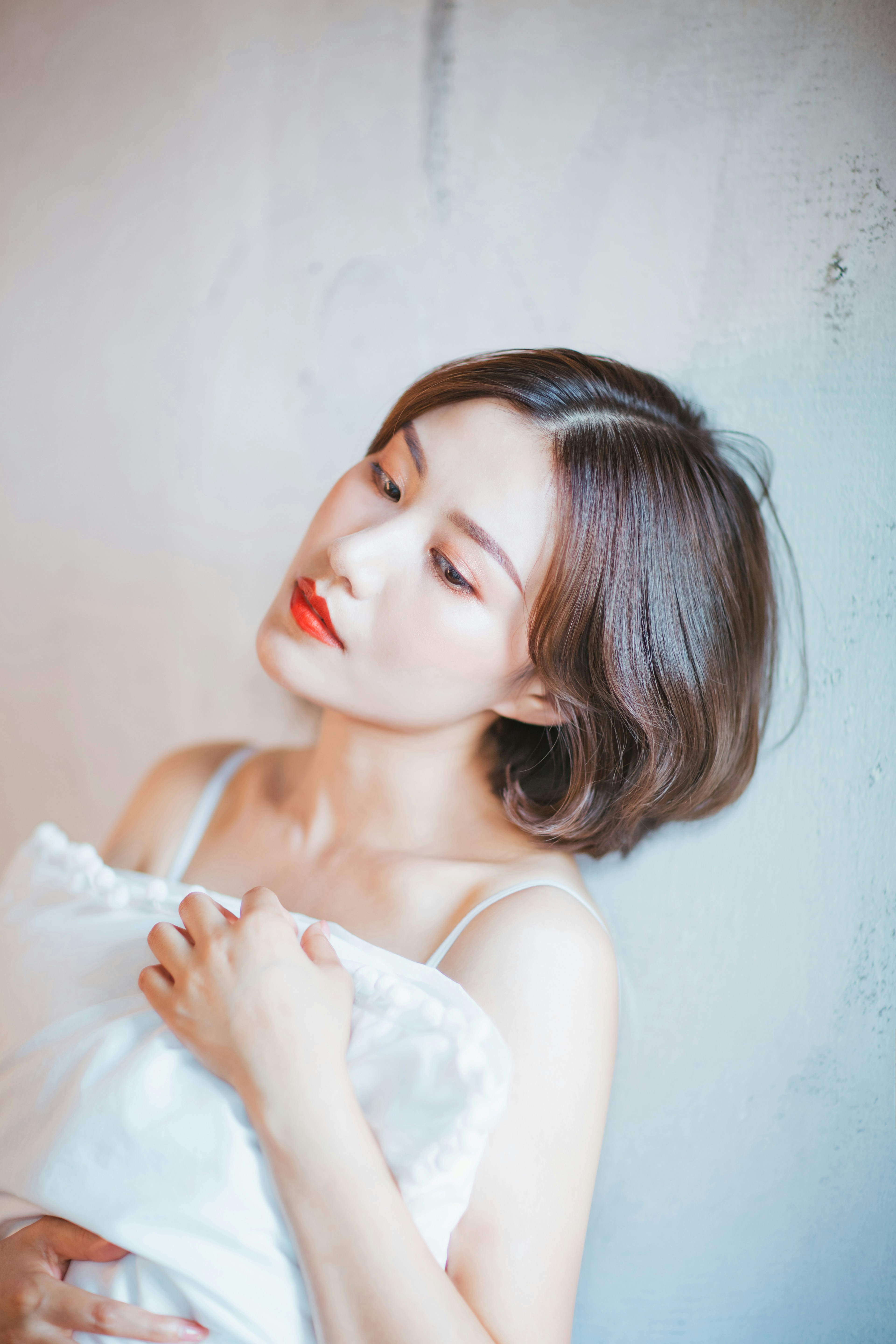 Una mujer con un vestido blanco sostenida de una almohada