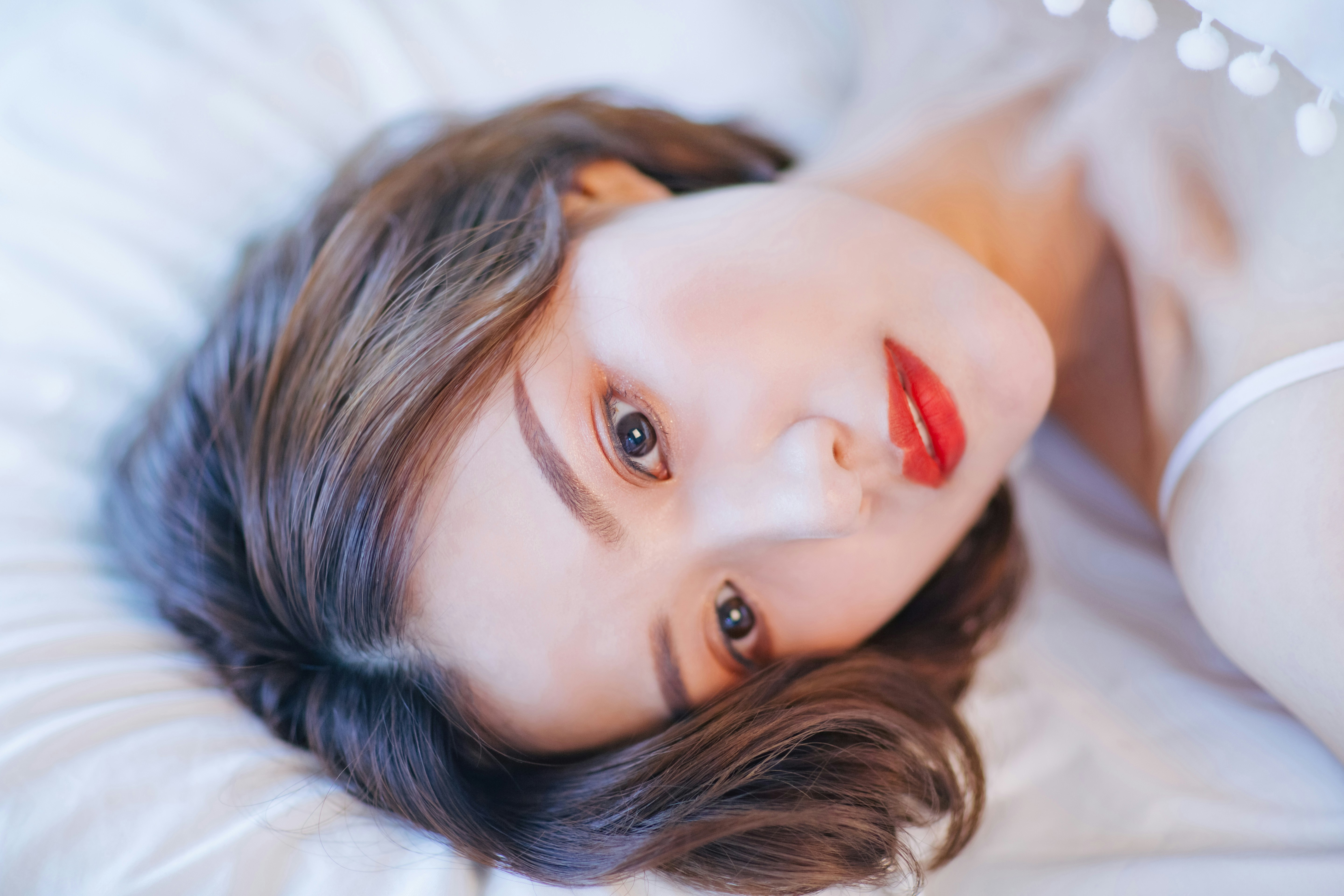 A woman laying on top of a white bed