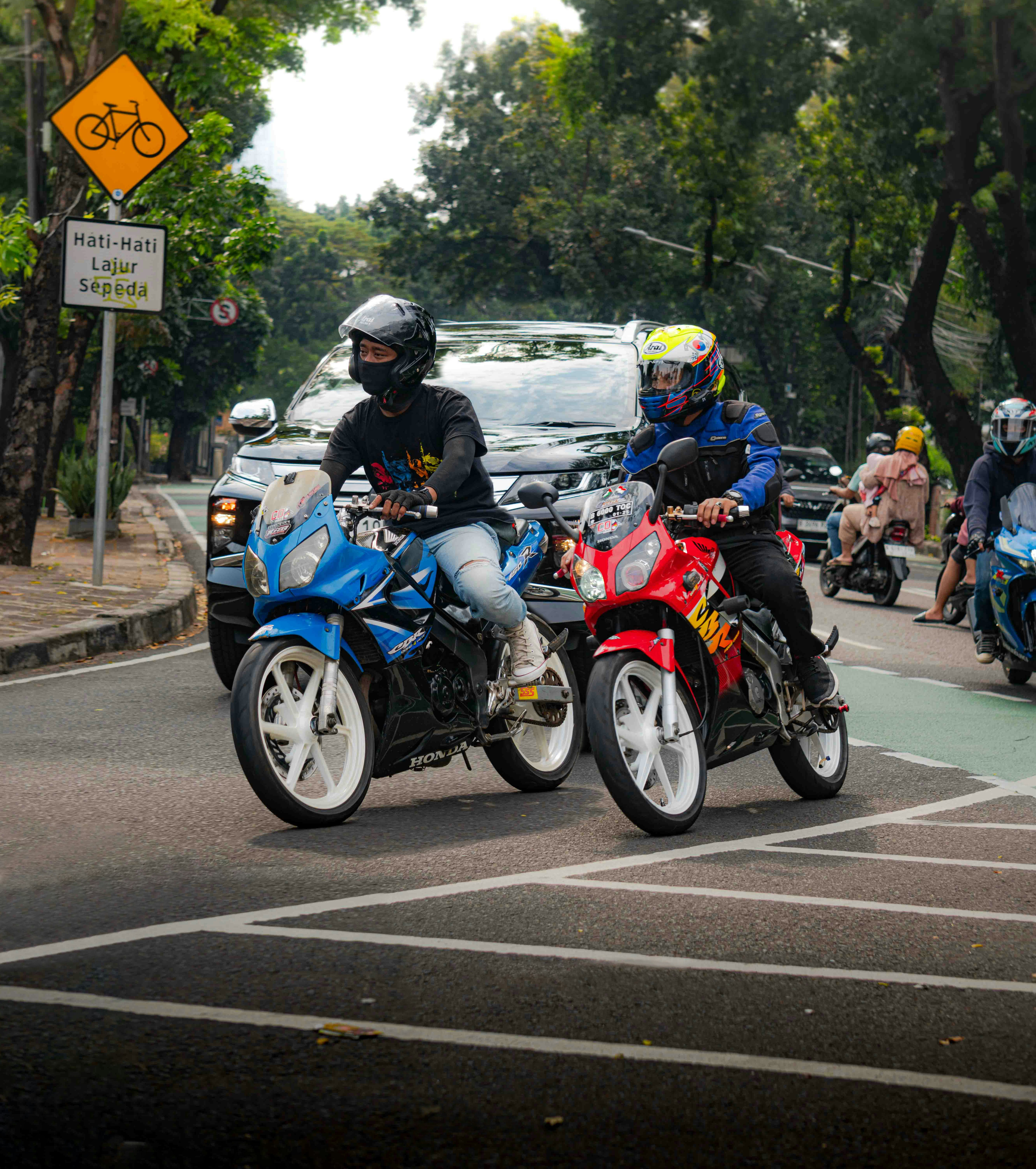 A group of people riding motorcycles down a street