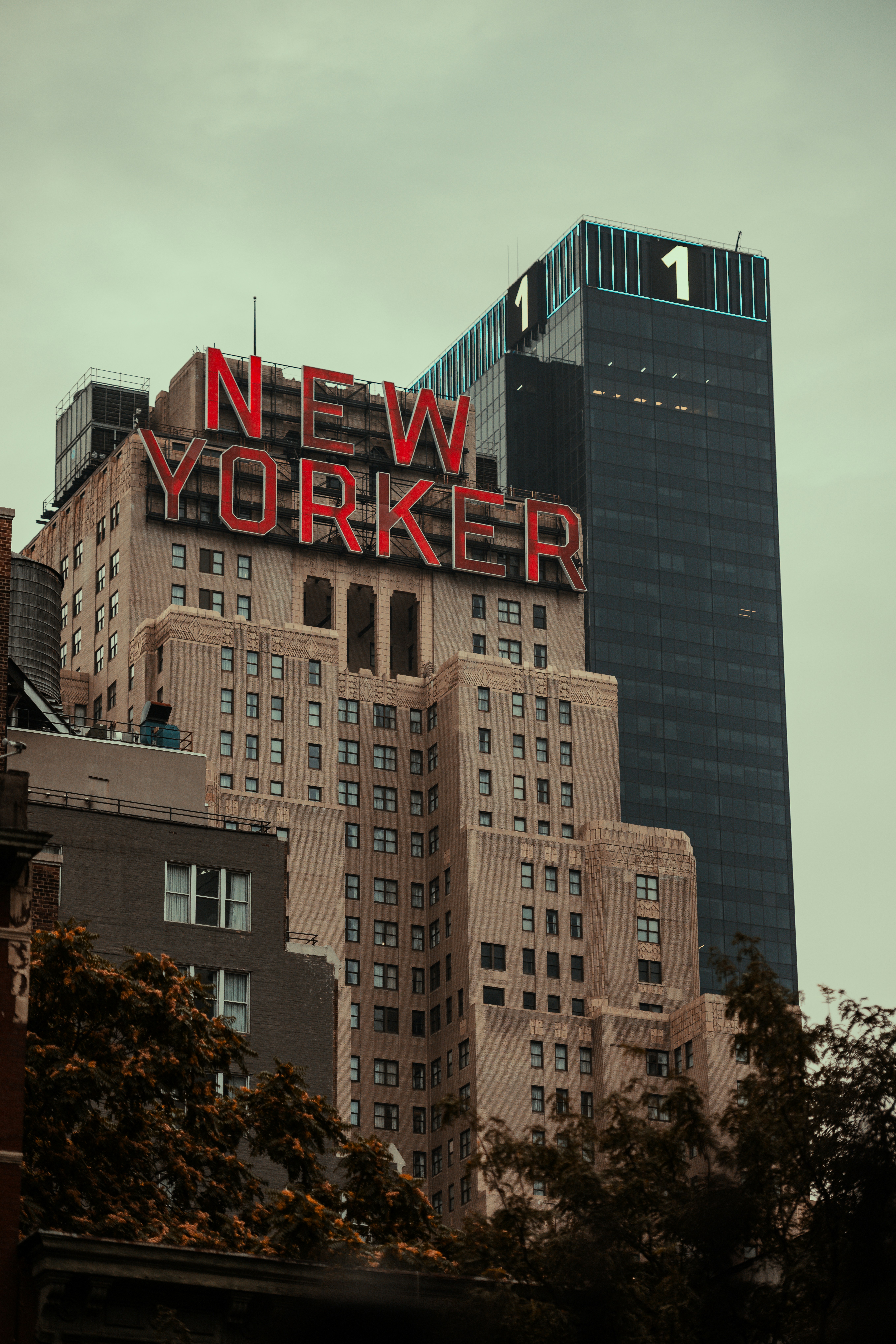 A very tall building with a neon sign on top of it