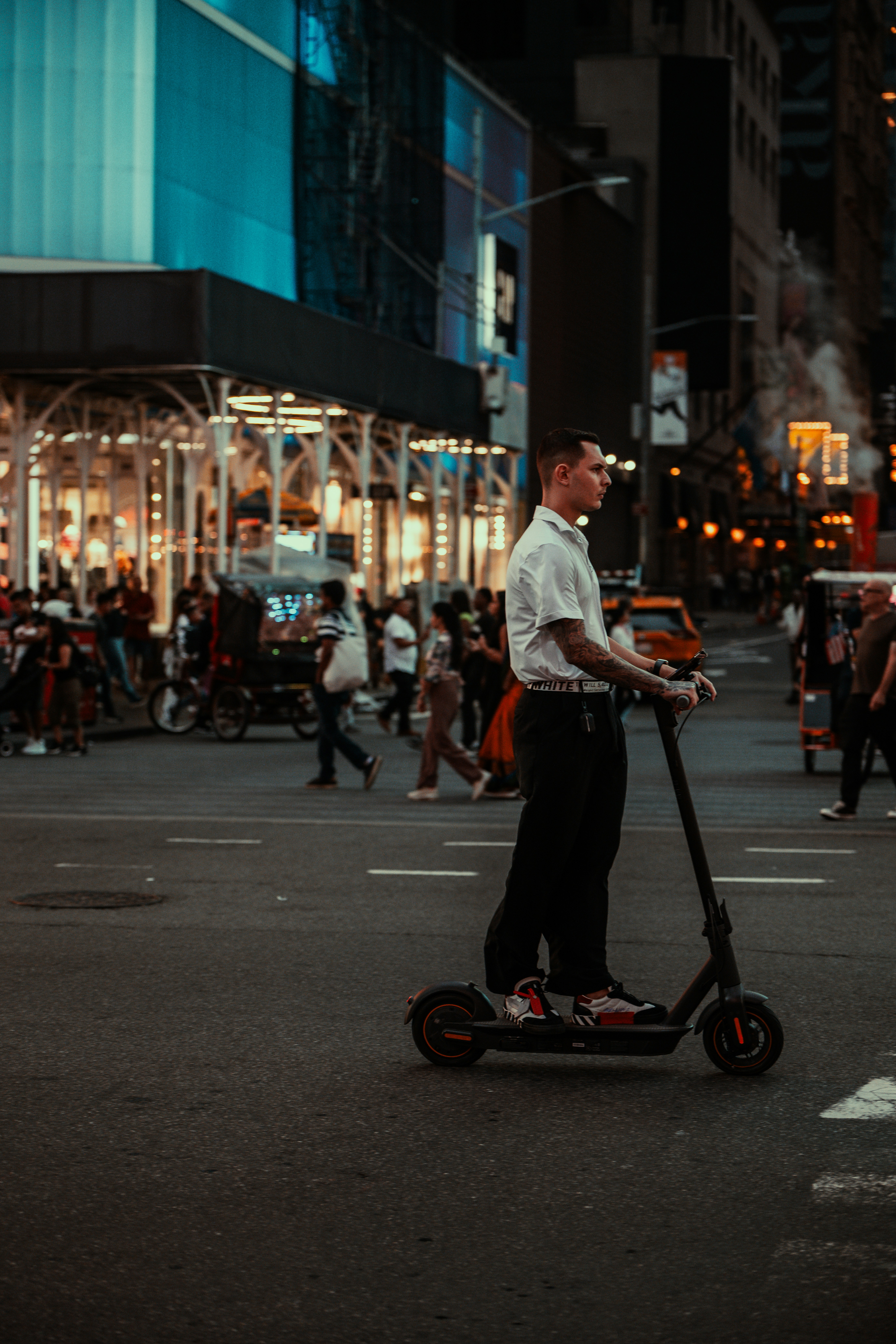 A man riding a scooter down a city street
