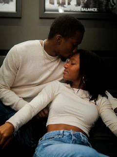 A man and a woman cuddling on a couch