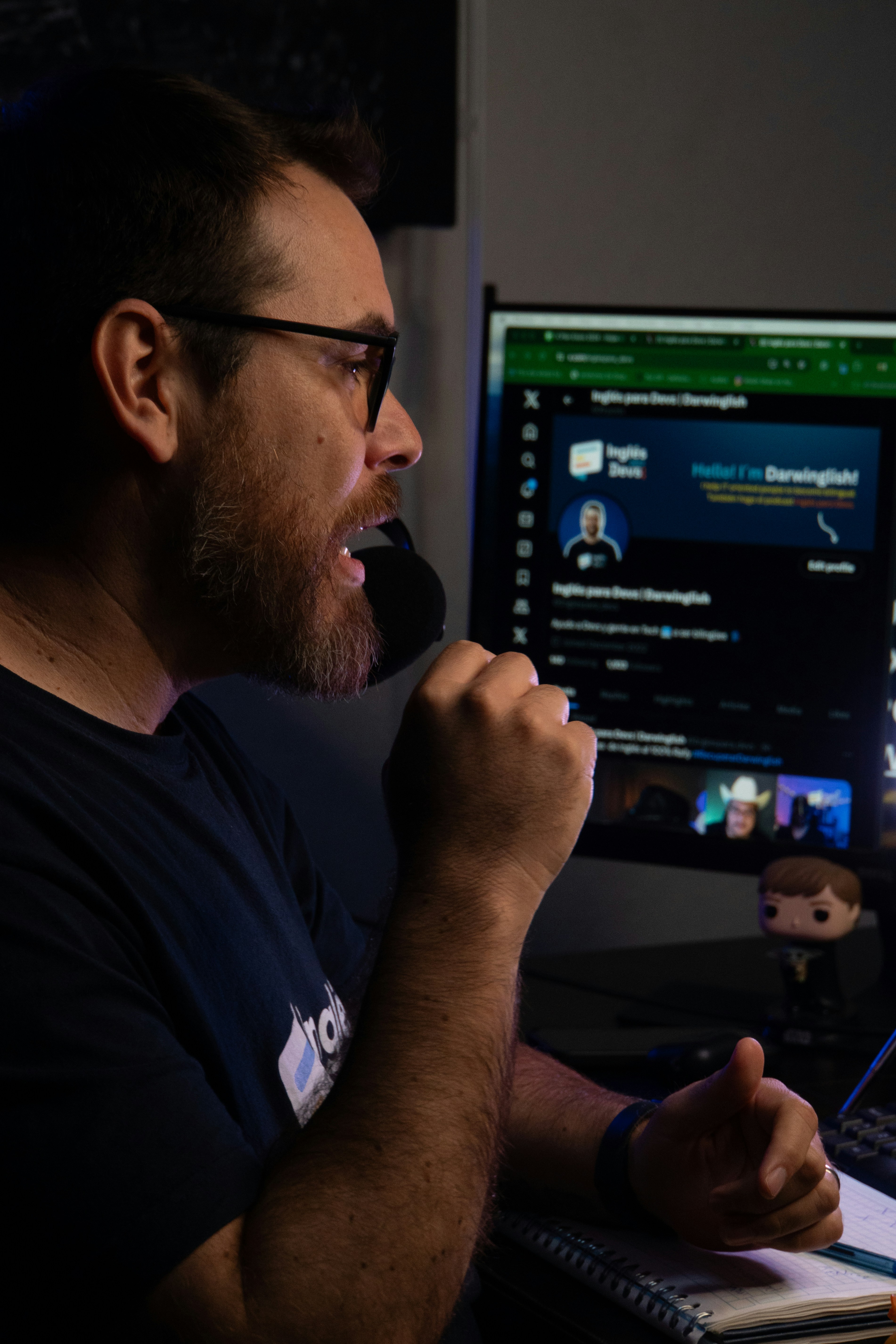 A man sitting in front of a computer with a microphone