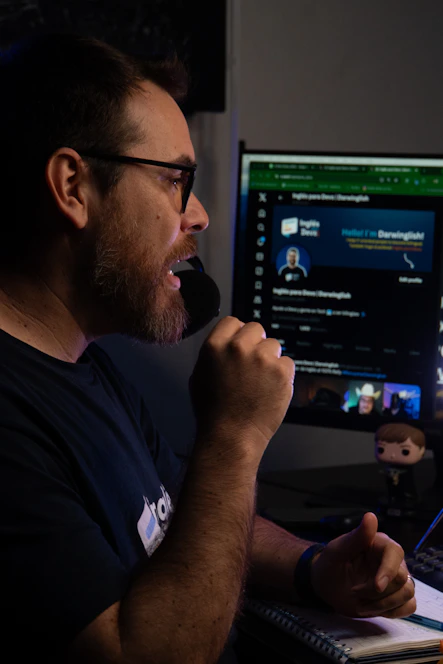 A man sitting in front of a computer with a microphone