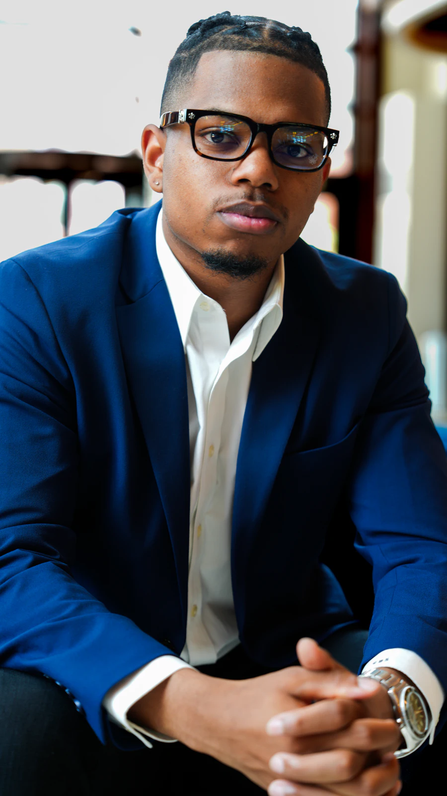 Man in a suit and glasses, seated
