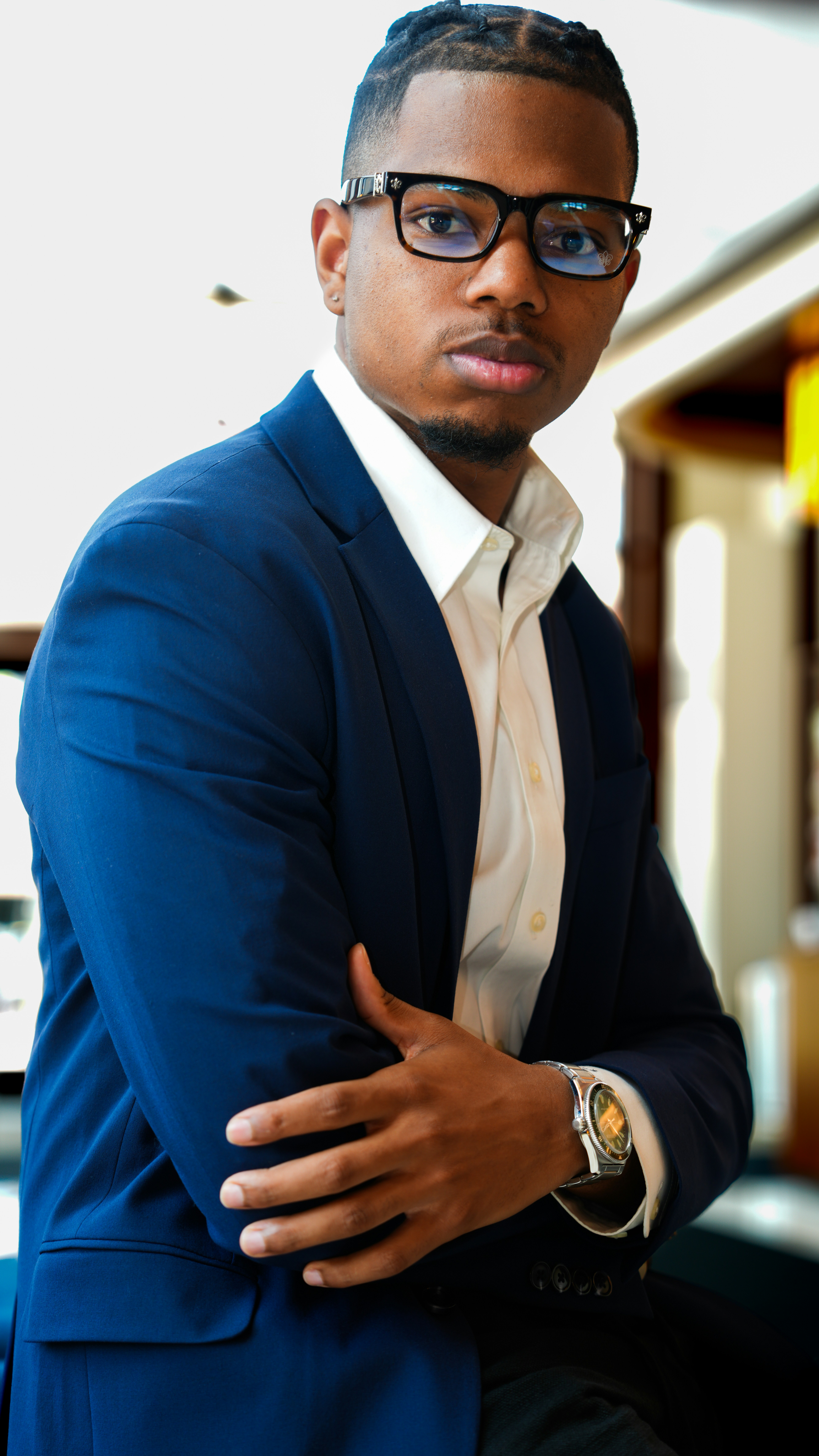 Young Black man smiling confidently in a collared shirt, warm indoor lighting
