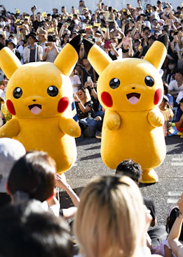 Un gran grupo de personas viendo un desfile con Pikachu 