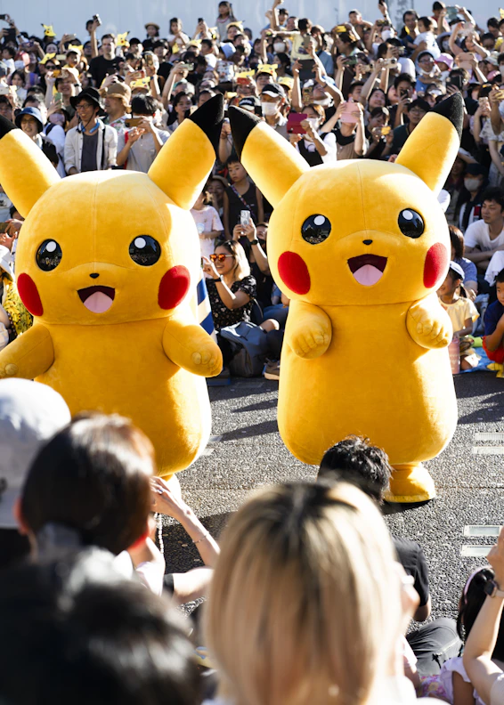 Un gran grupo de personas viendo un desfile con Pikachu 